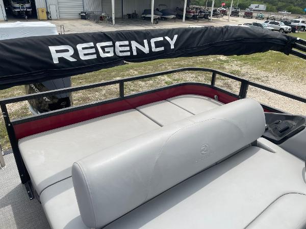 2023 Regency 250DL3 boat with cushioned seating and protective cover.