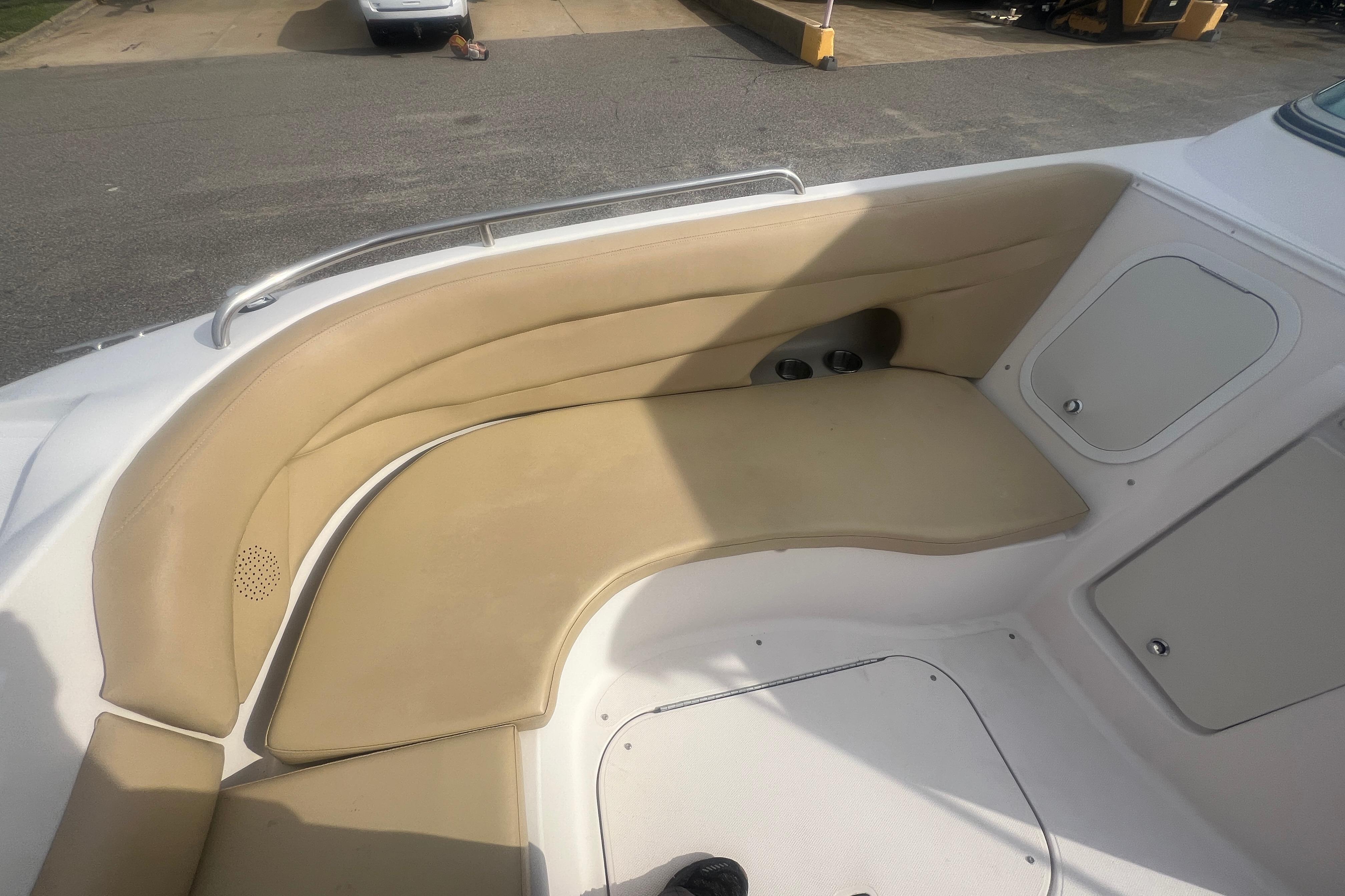 2002 Hurricane SunDeck 260 OB boat interior with beige seating and storage compartments.