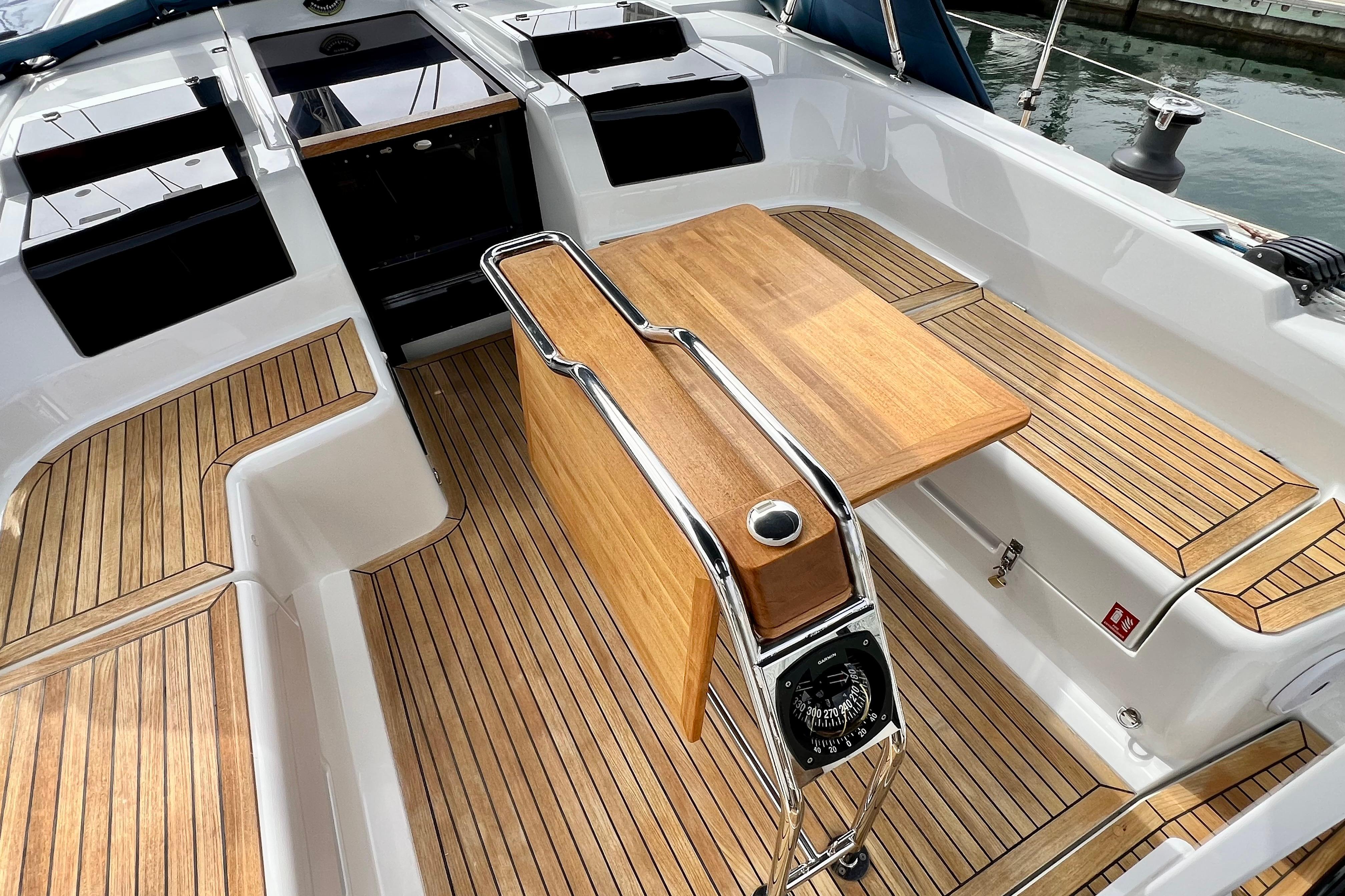 Cockpit of 2016 Hanse 455 sailboat with teak flooring and foldable wooden table.