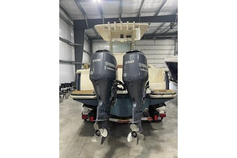 2015 Scout 255 LXF boat with dual Yamaha 150 engines in a warehouse setting.