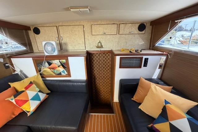 1980 Chris-Craft 381 Catalina interior with colorful cushions and wood paneling.