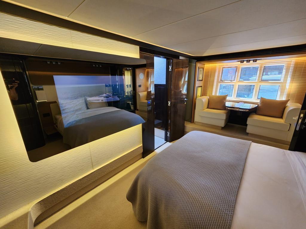 Luxurious bedroom interior of 2019 Azimut 77S yacht with modern decor and large windows.