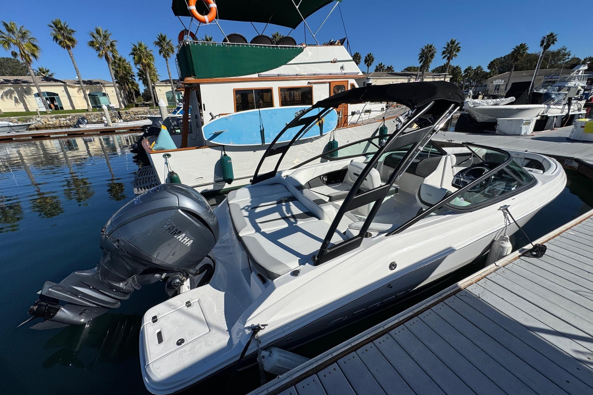 2026 Regal 21 OBX boat docked at marina with Yamaha outboard motor.