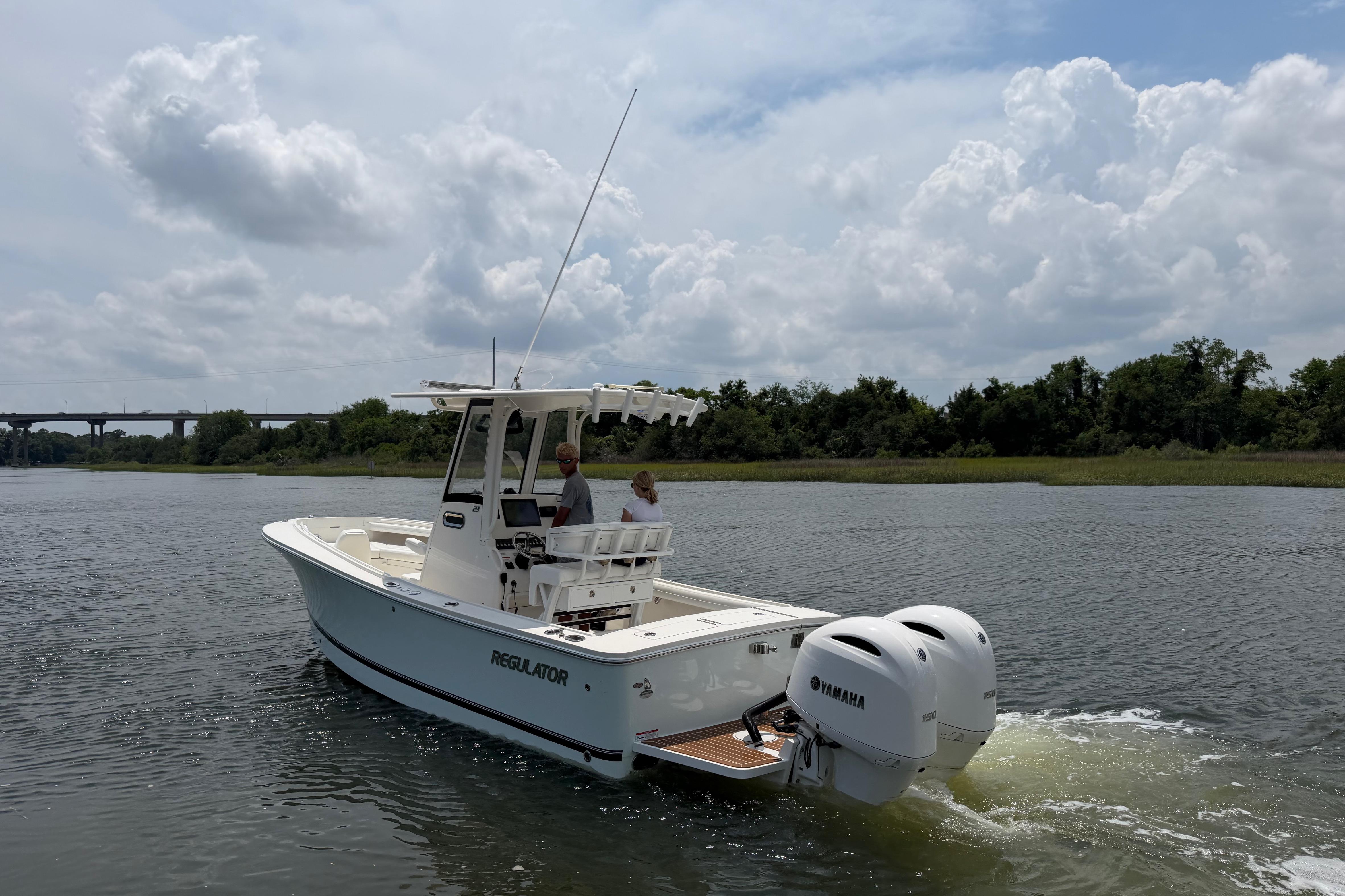 2022 Regulator 23 boat with dual Yamaha engines cruising on a scenic river.