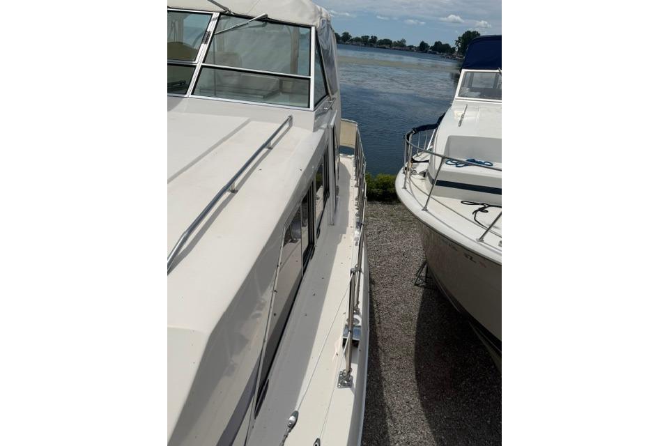 1980 Chris-Craft 381 Catalina yacht docked beside another boat, near a serene waterway.