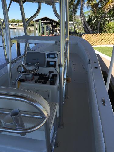 A 2011 Andros 26 Tarpon with an open cockpit and helm station. It is docked in a calm area.
