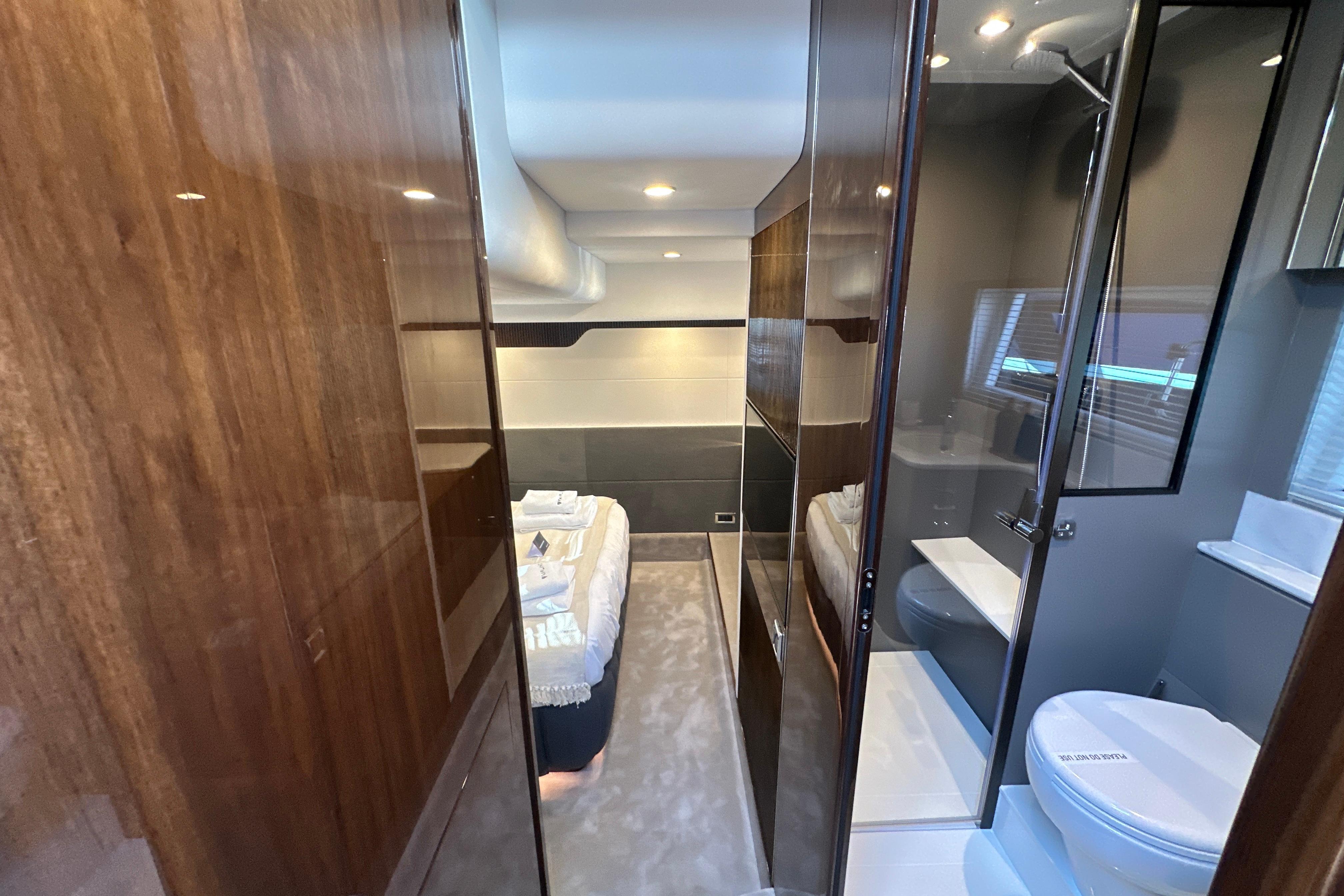 Luxurious interior of 2026 Fairline Targa 47 GT yacht, featuring modern bathroom and cozy bedroom.