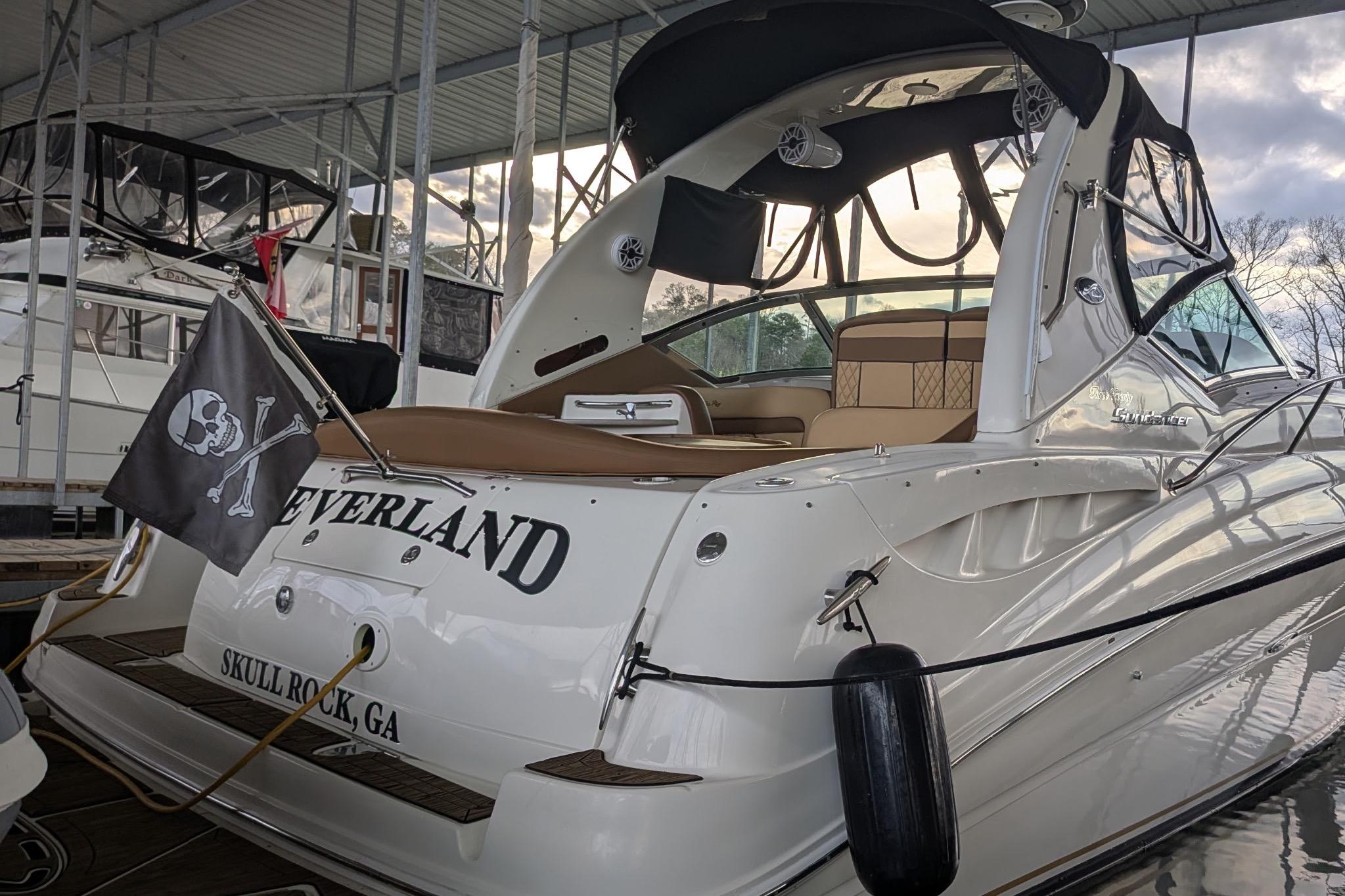 2002 Sea Ray Sundancer 320 docked, featuring a pirate flag and "Neverland" name.