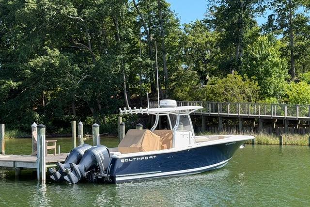 2014 Southport 29 FE boat docked by a lush, wooded shoreline.