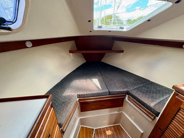 Interior of a 1989 Catalina 34 with cozy cushions and wood accents.