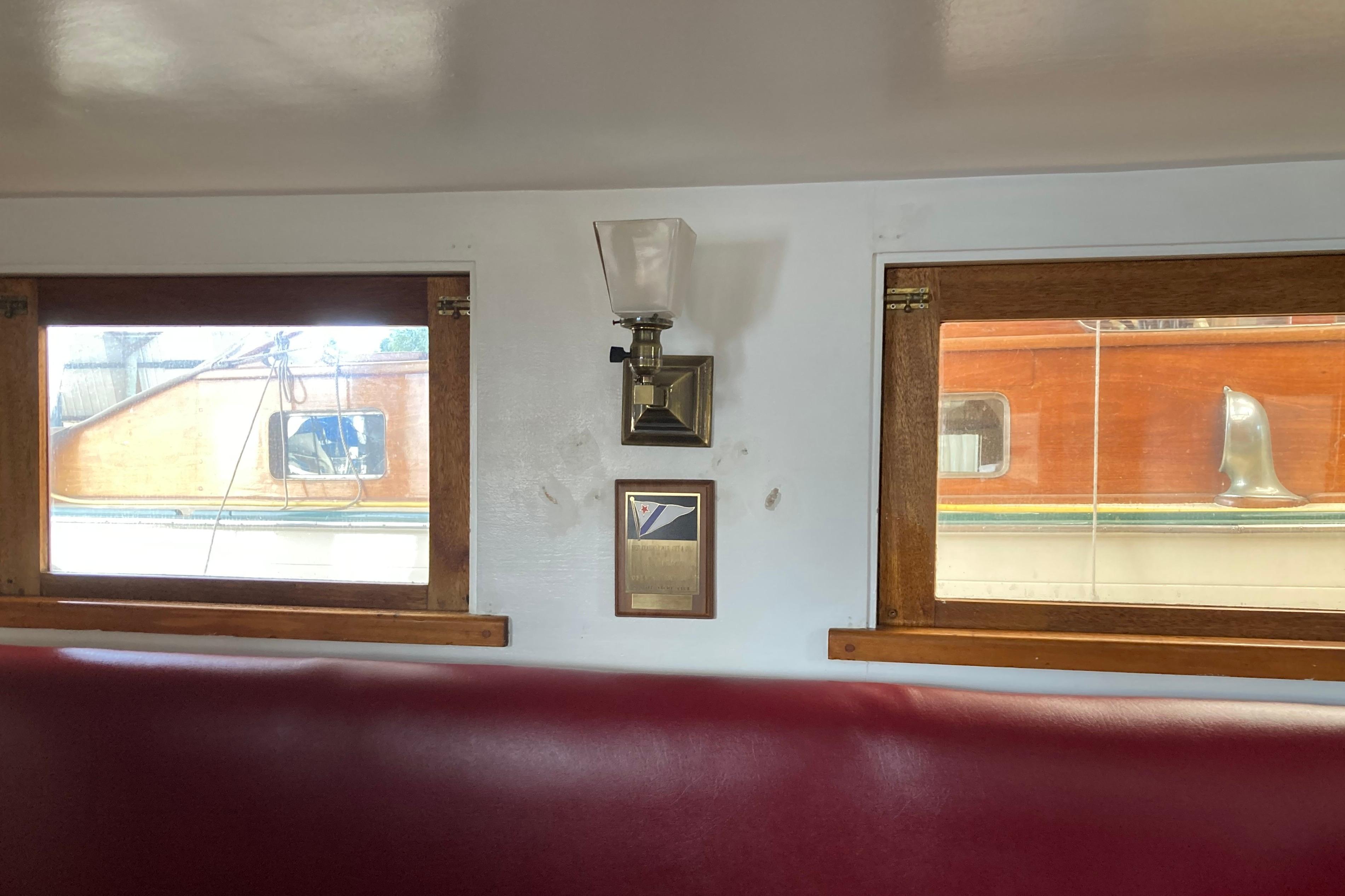 Interior of a 1942 Grenfell 42 Custom boat with wooden-framed windows and a wall lamp.
