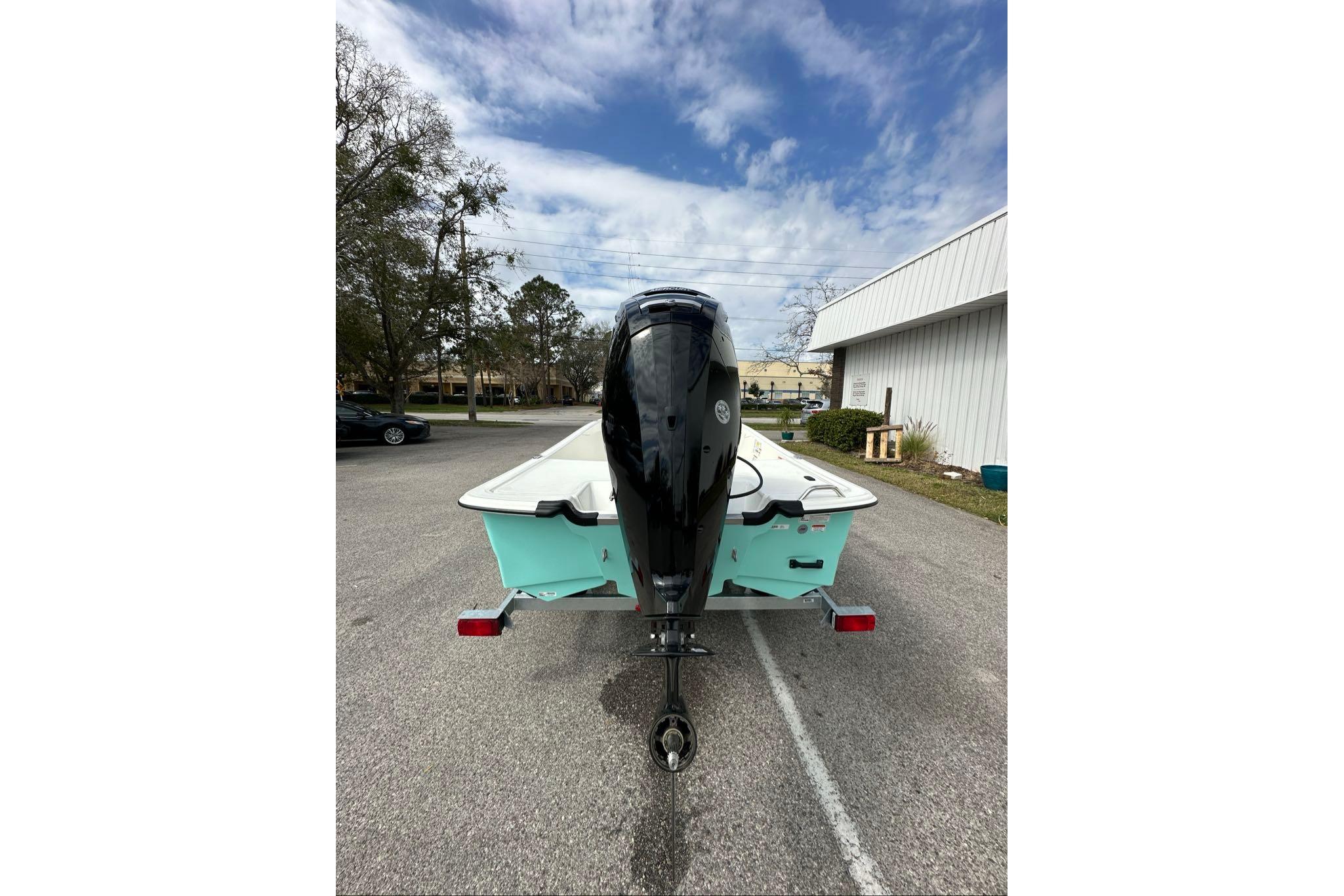 2026 Mako Pro Skiff 17 CC boat on trailer, rear view, parked outdoors.