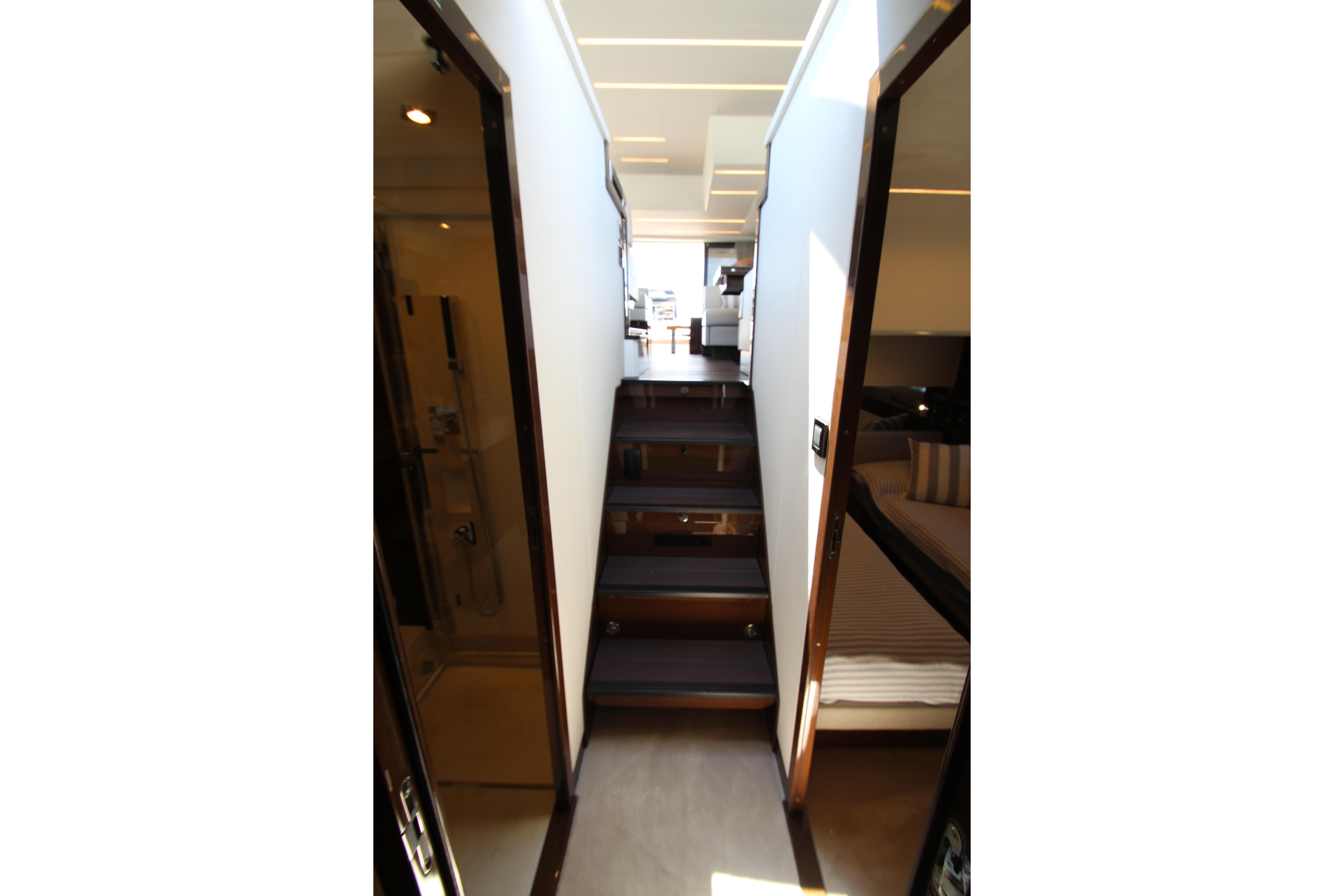 Interior hallway of 2022 Prestige 520 yacht with modern design and wooden stairs.