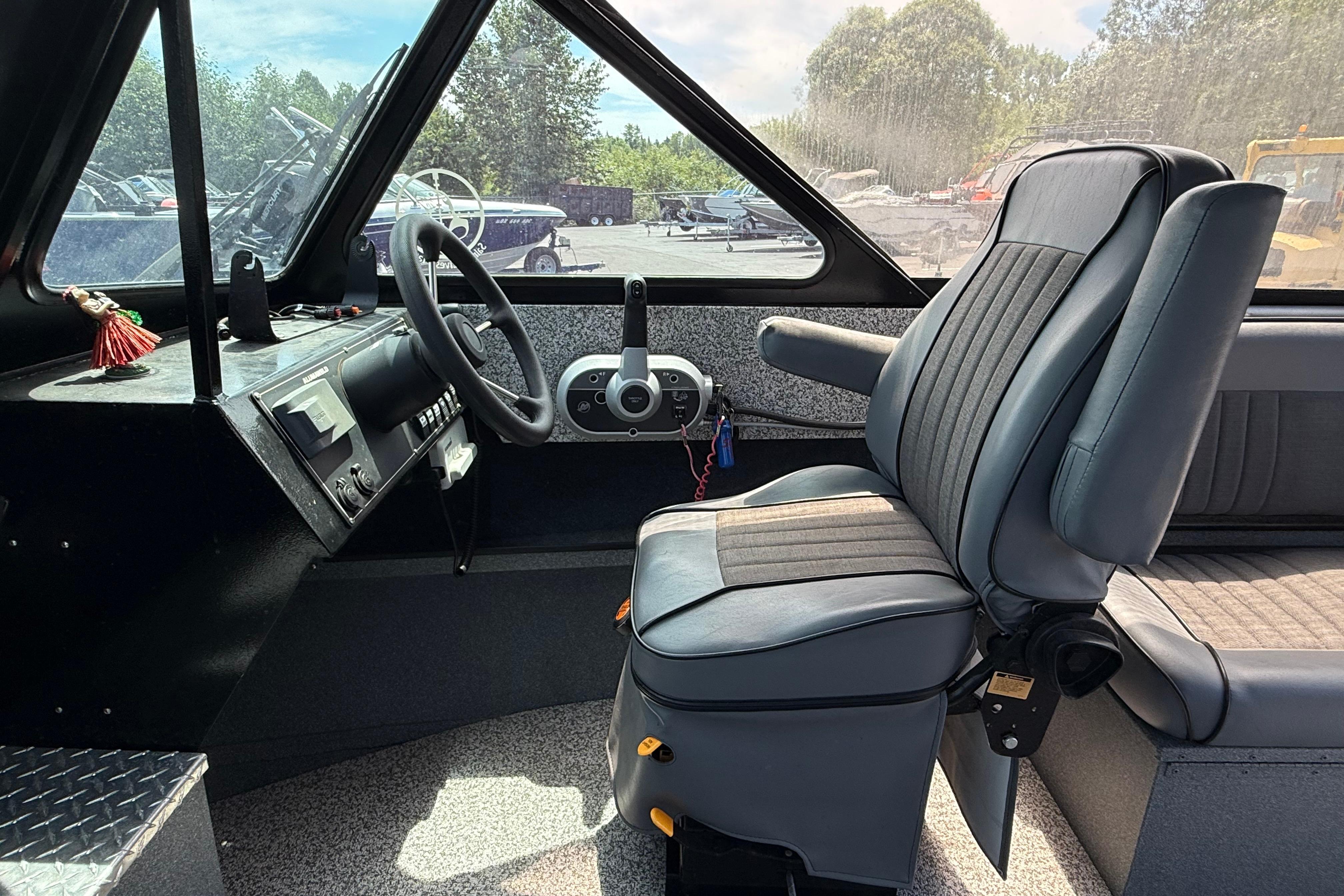 2019 Alumaweld Intruder Hard Top 22' boat interior with steering wheel and captain's chair.