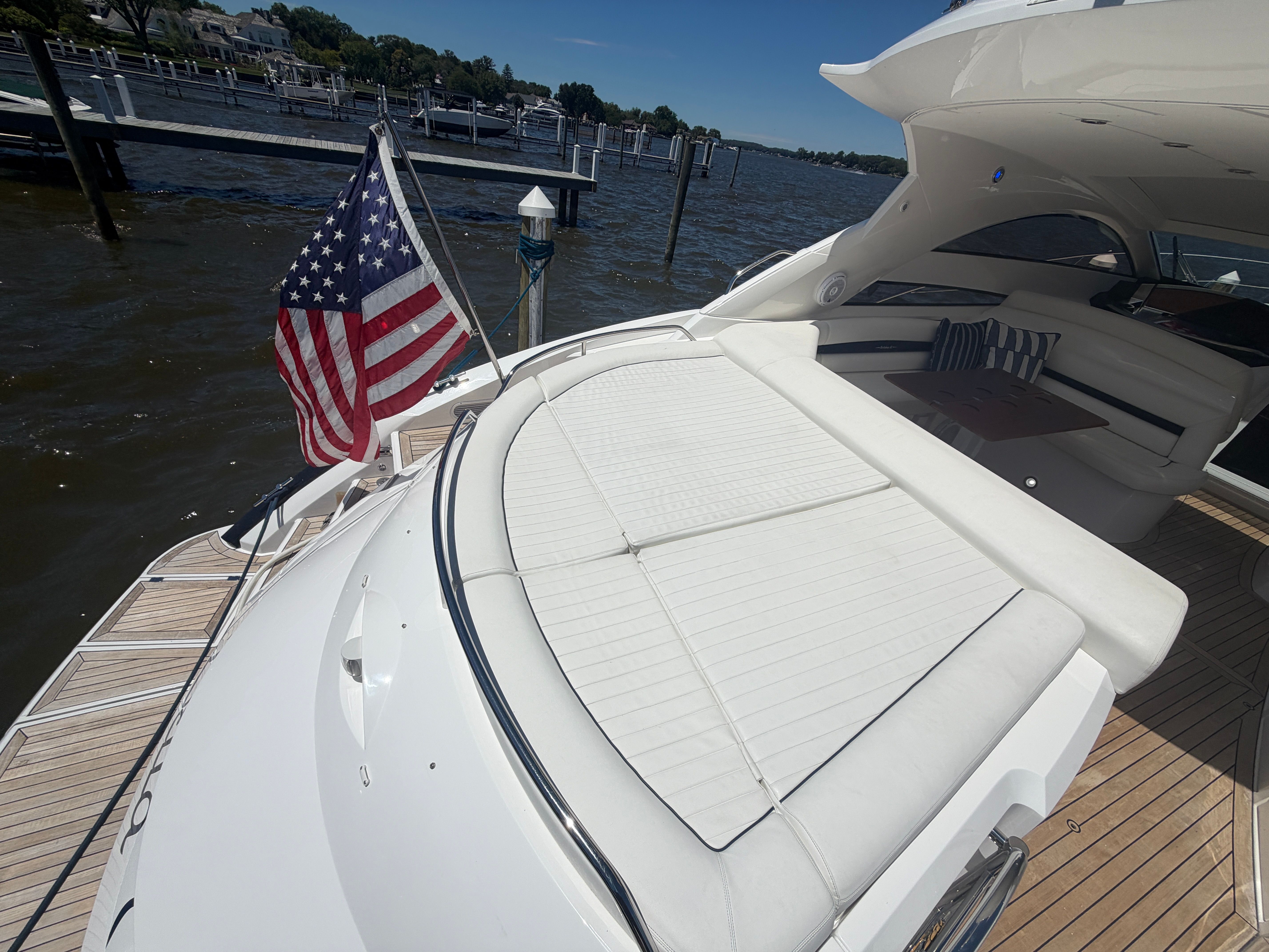 The image shows the stern of a 2008 Sunseeker Portofino 53 with a large sunbed and an American flag.