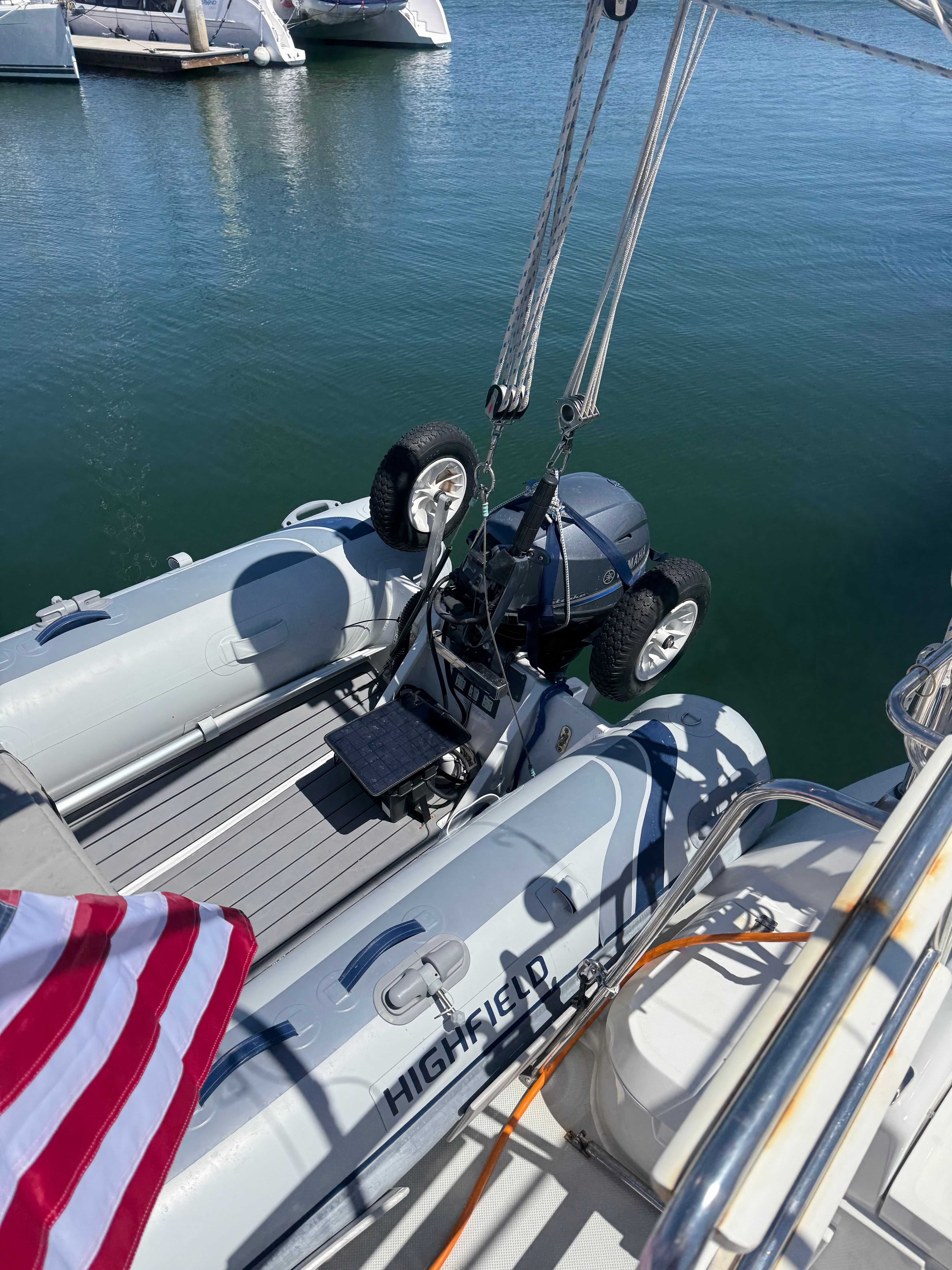 A Highfield Classic 310 inflatable boat is suspended by a crane over the water.