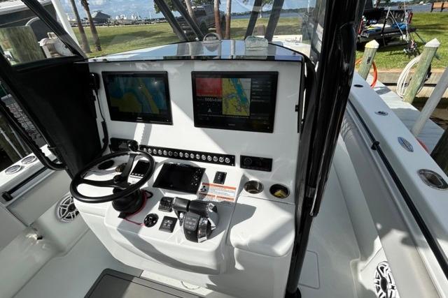 2023 Contender 32 ST boat cockpit with dual navigation screens and control panel.