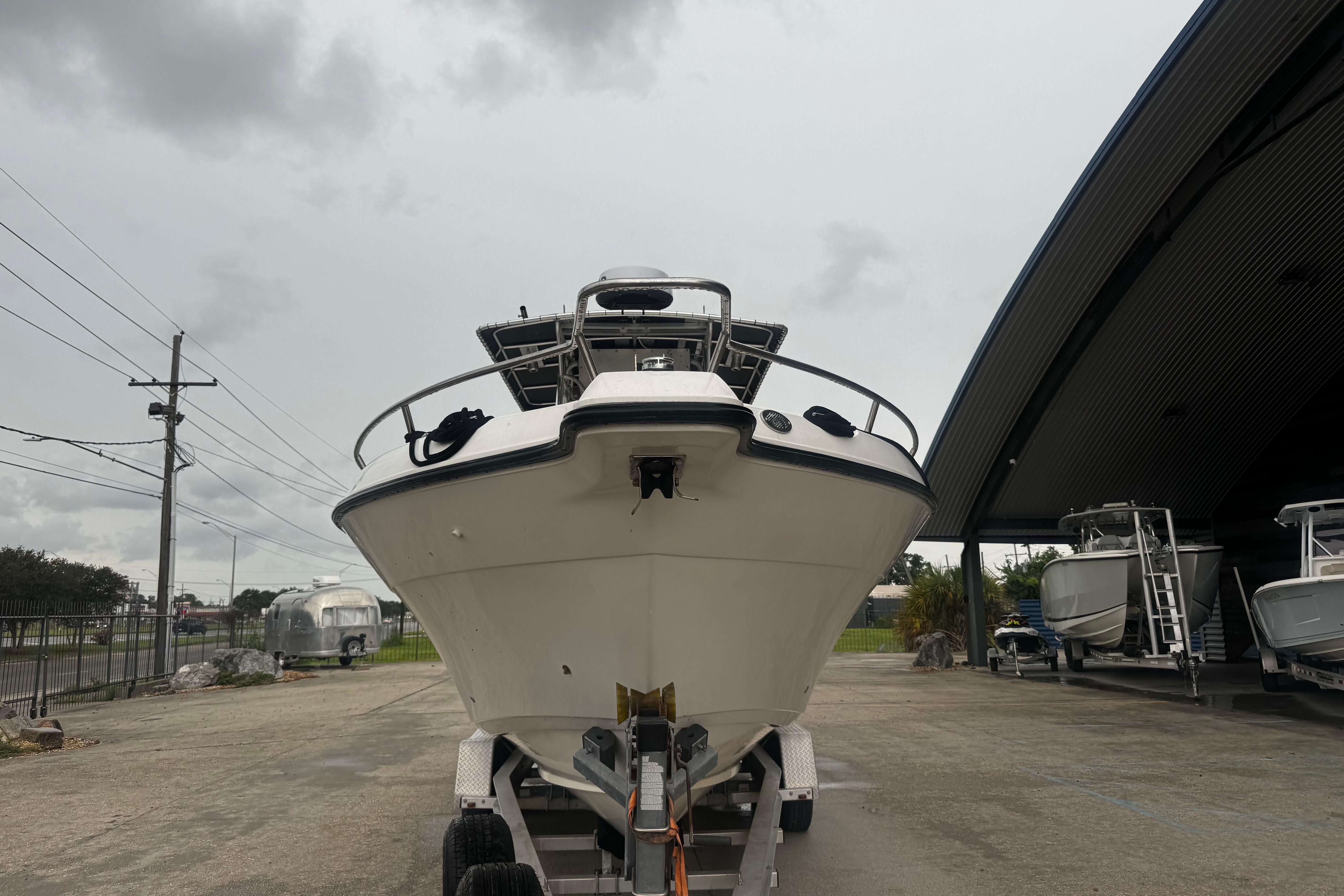 2004 Century 2900 Center Console boat on trailer under cloudy sky.