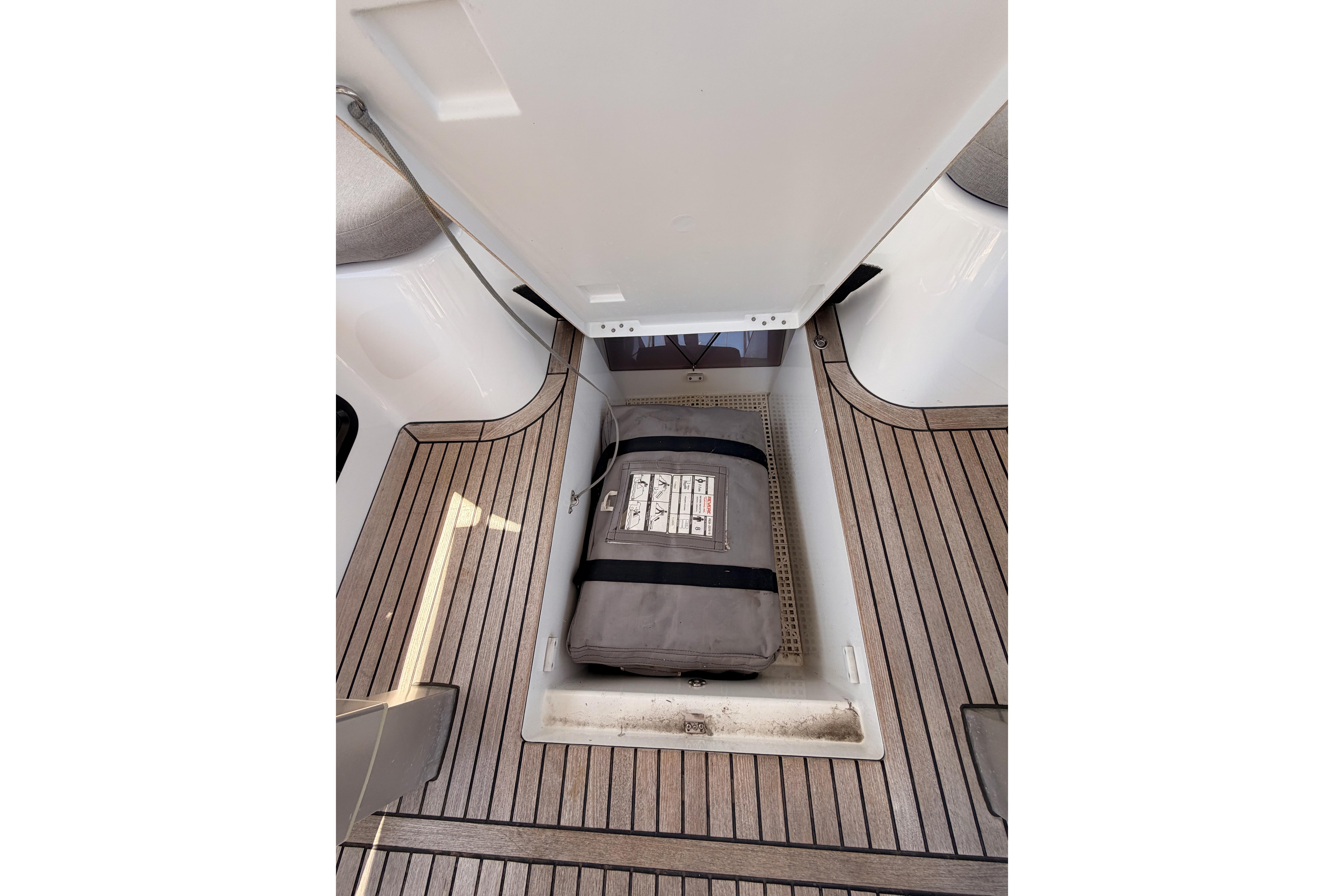 Storage compartment on 2022 Beneteau Oceanis Yacht 54 with wooden deck flooring.