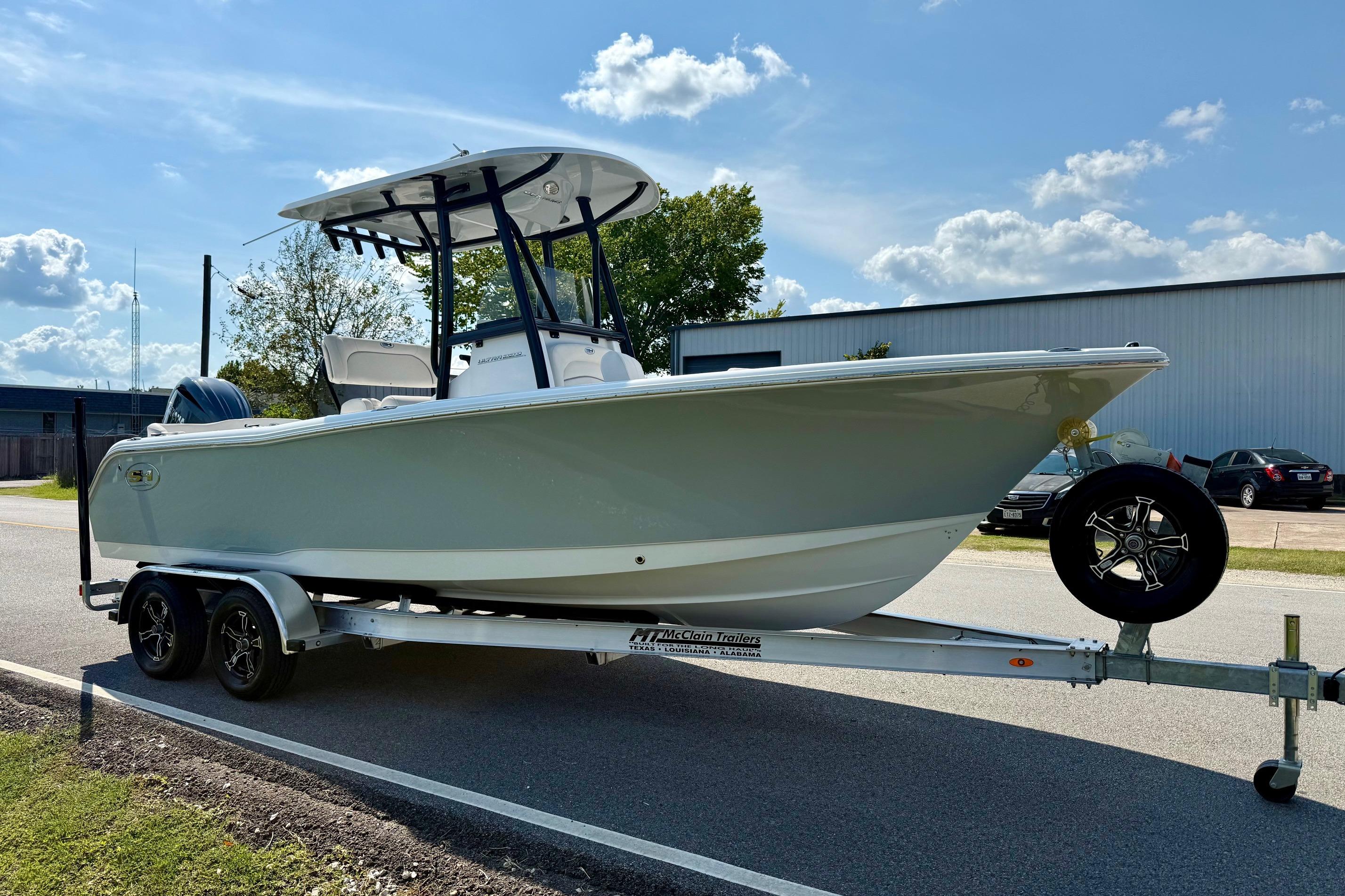 2026 Sea Hunt Ultra 229 boat on trailer, parked outdoors under a clear sky.