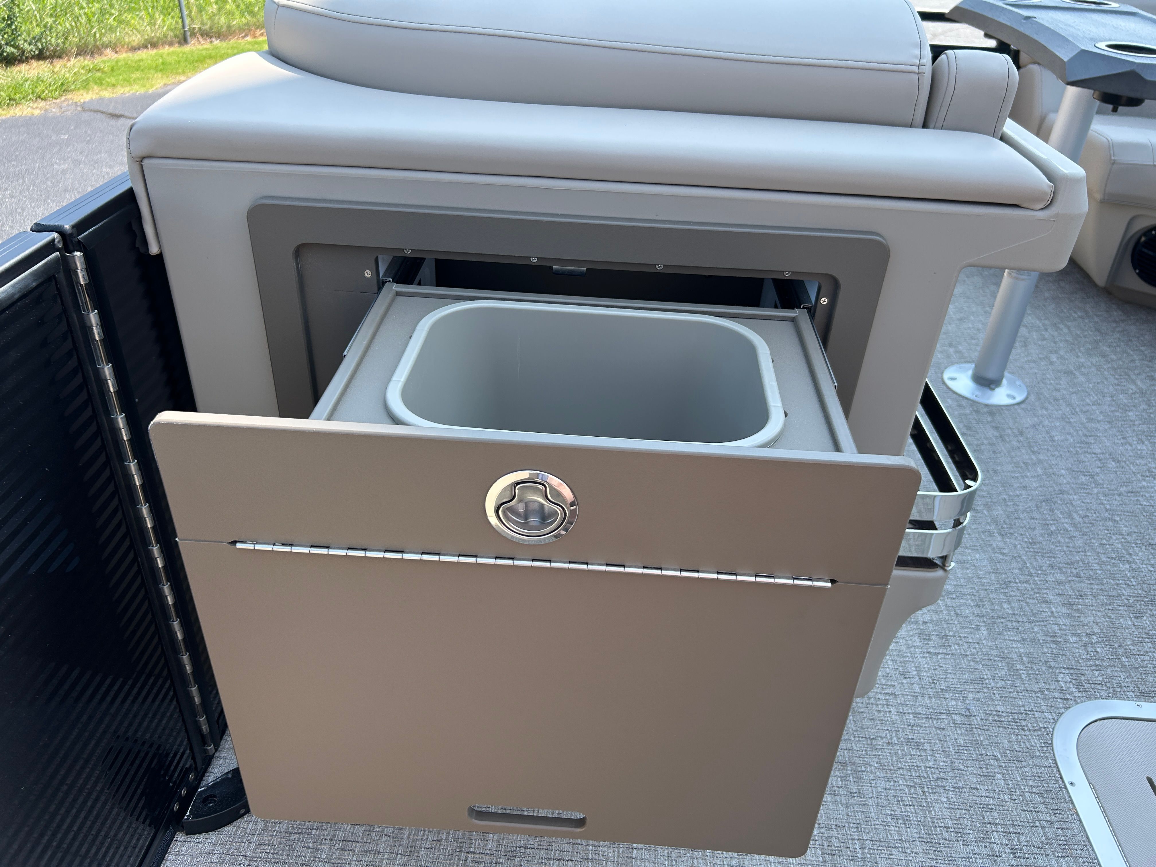 An open storage compartment with a pull-out drawer on a boat.