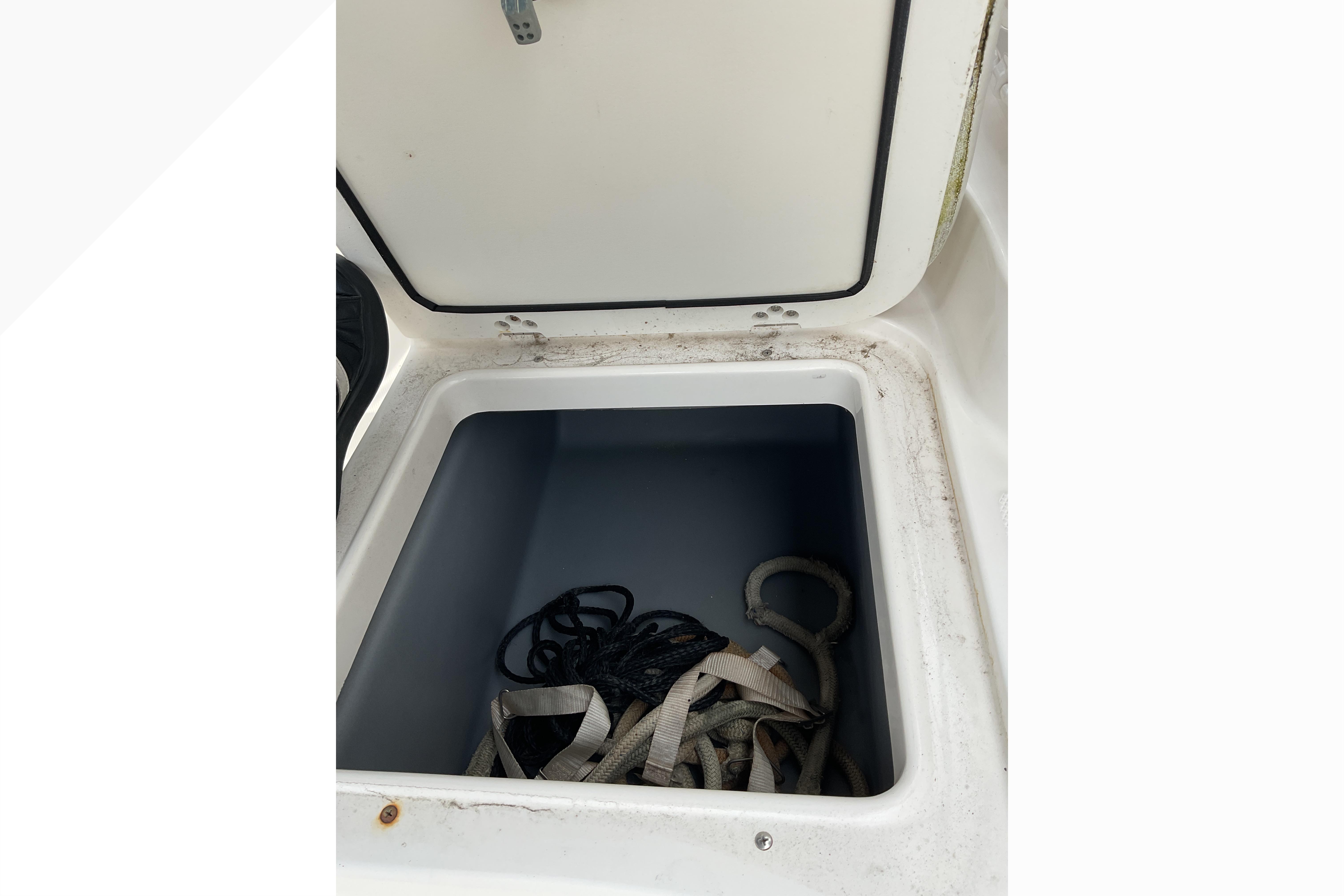 Open storage compartment on 2012 Wellcraft 232 Coastal boat with ropes inside.