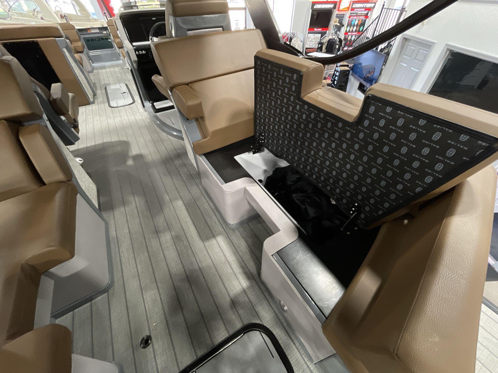 Interior of 2025 Balise Horizon 26C boat with tan seating and storage compartments.