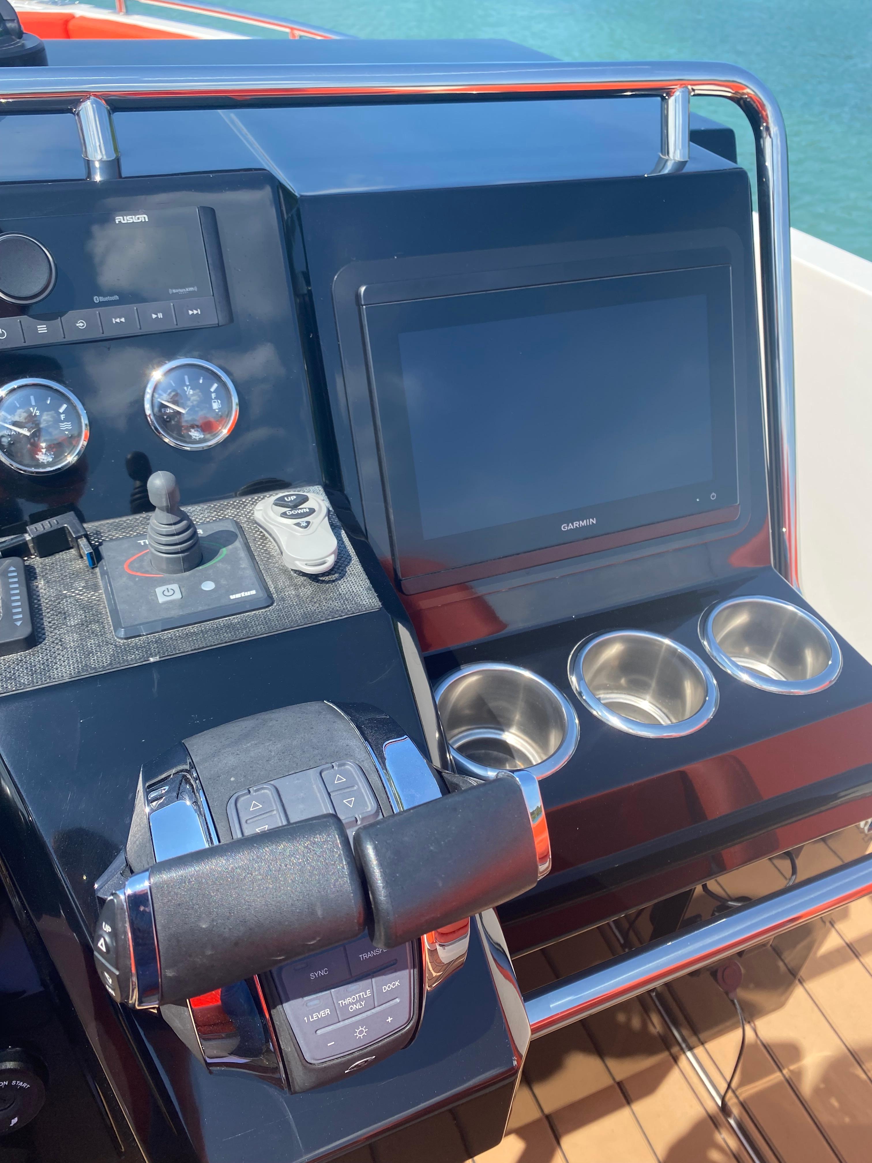 Control panel of a 2020 De Antonio Yachts D 28 with navigation screen and cup holders.