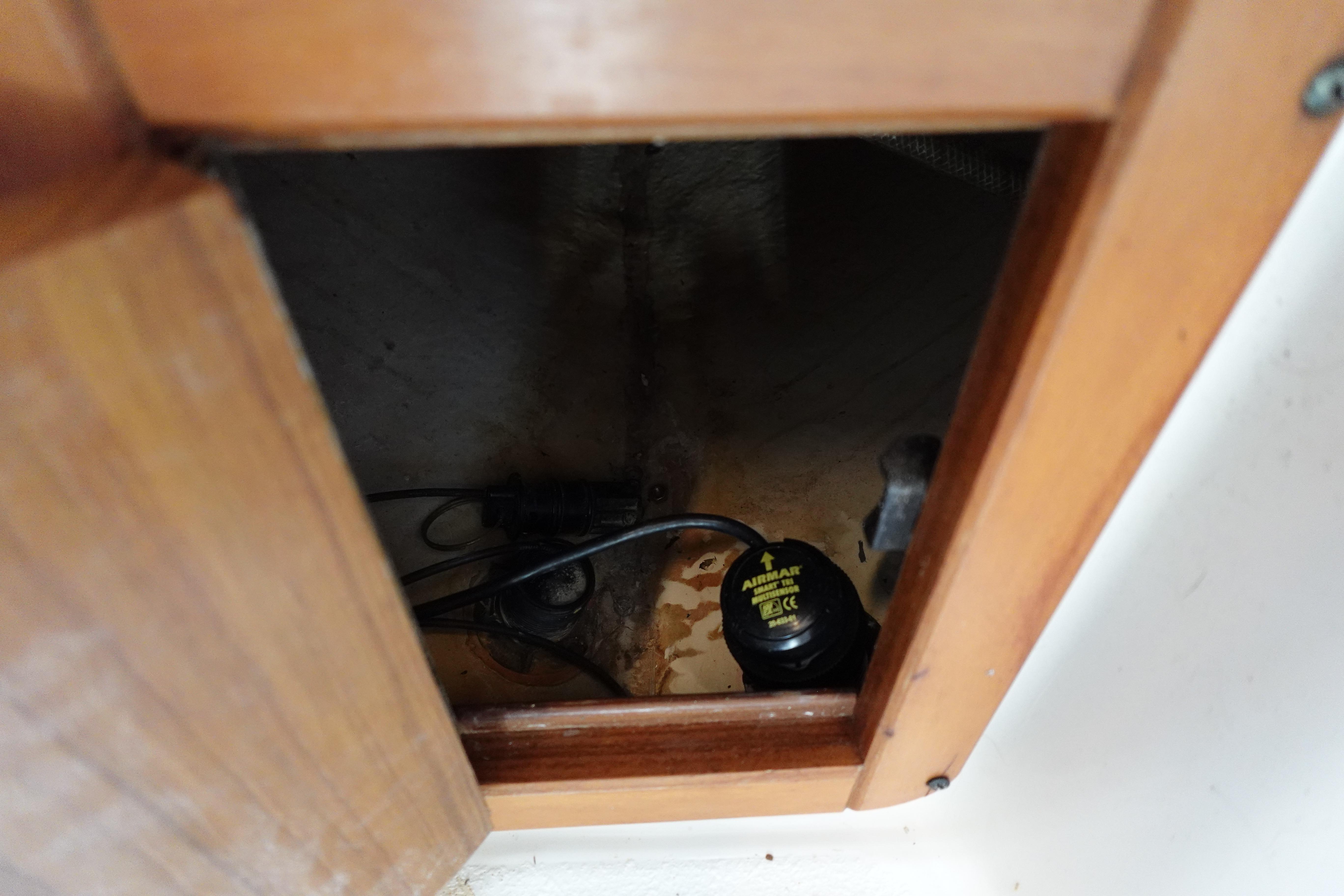Wooden compartment in a 1997 Catalina 28 boat, showing interior wiring and components.