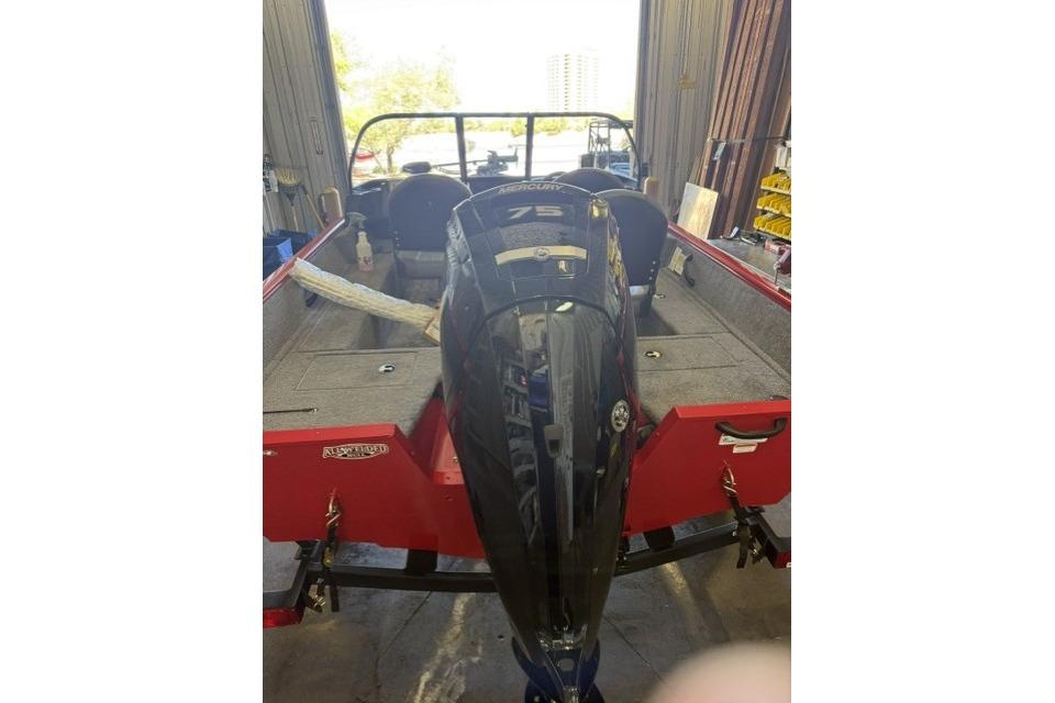 2026 Tracker Pro Guide V-16 WT boat with Mercury 75 engine in a garage.