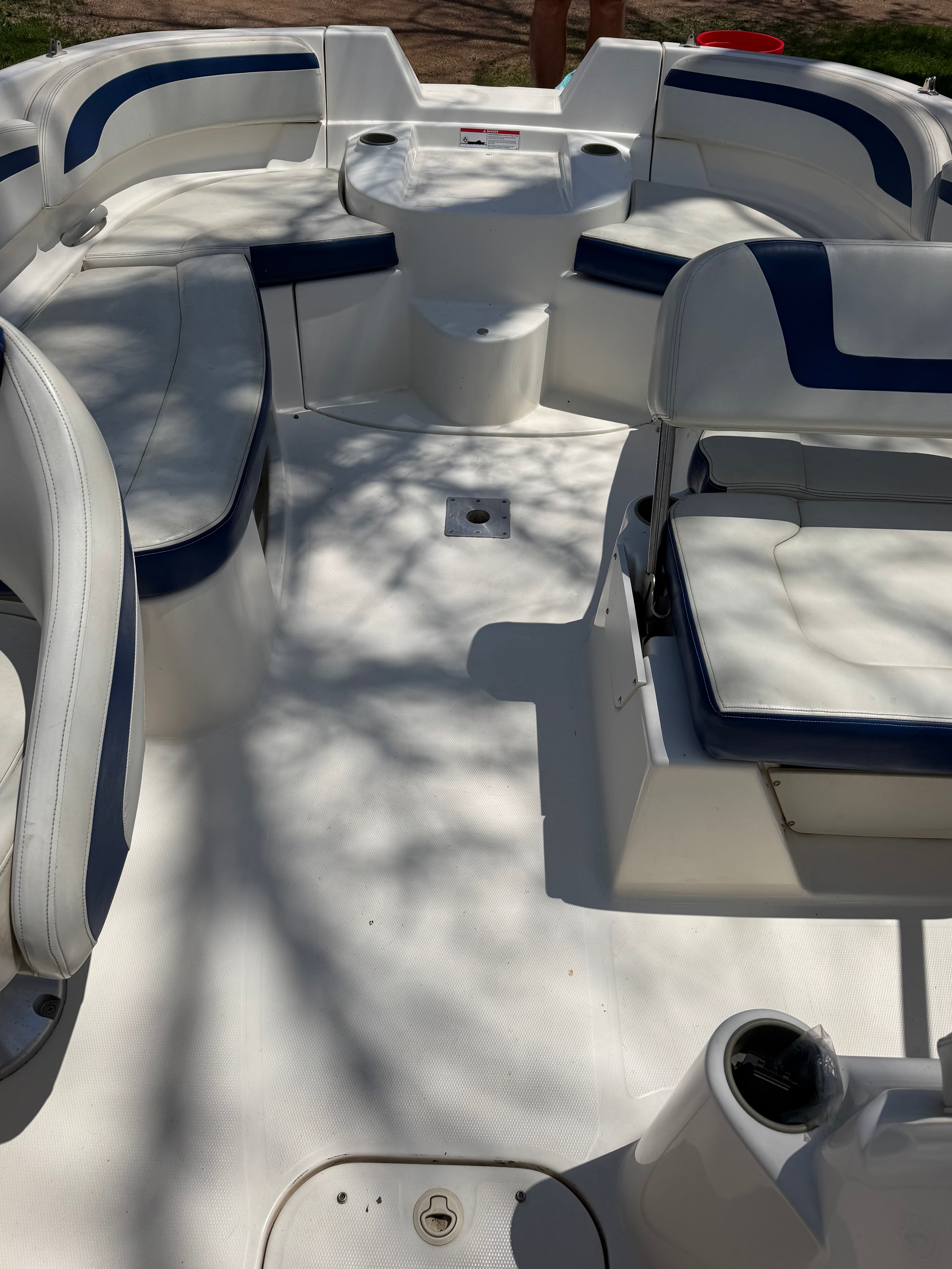 The image shows the open bow design of a 2005 Bayliner 212 with blue and white seating.