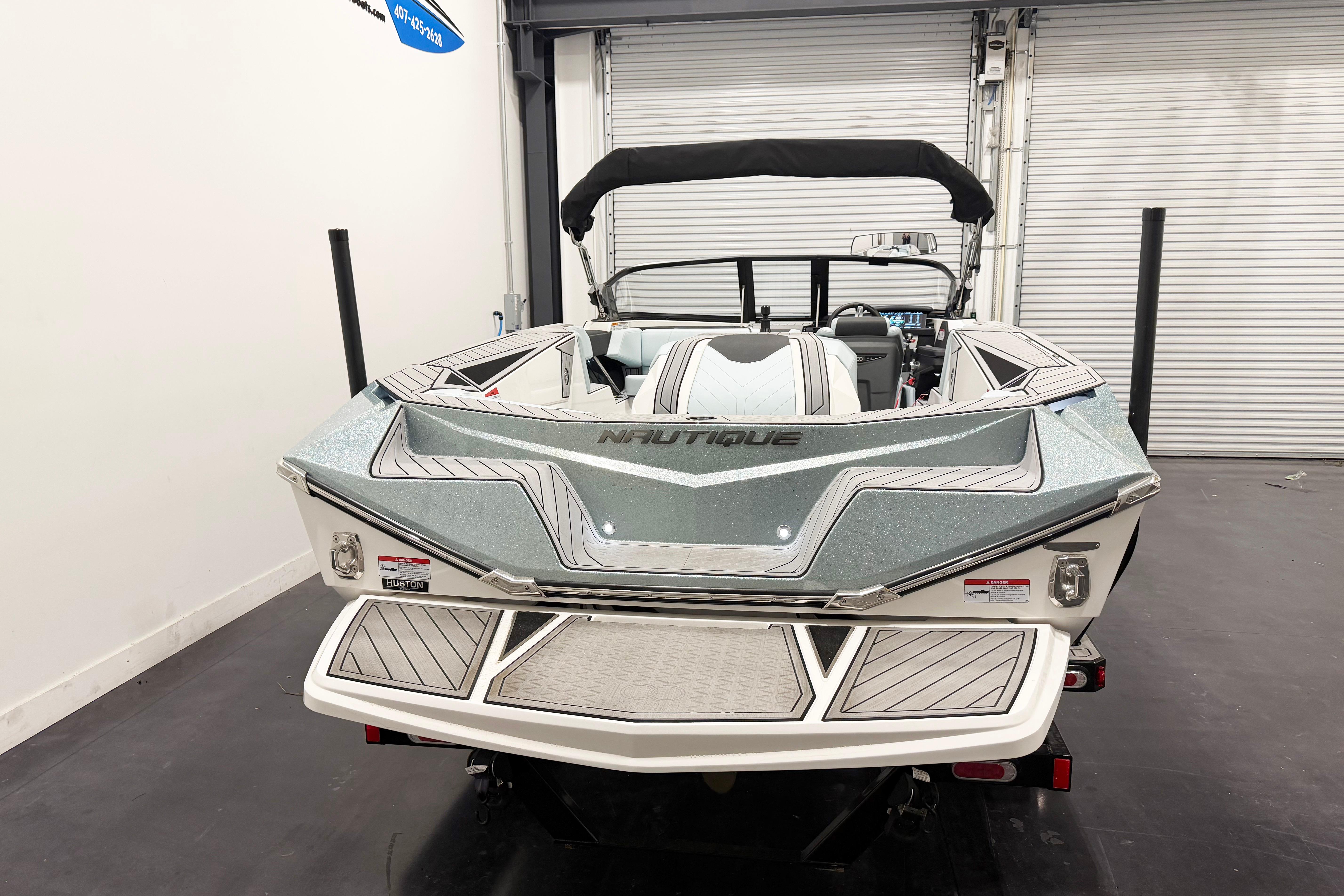 2025 Nautique Ski Nautique boat in showroom, rear view with sleek design and modern features.