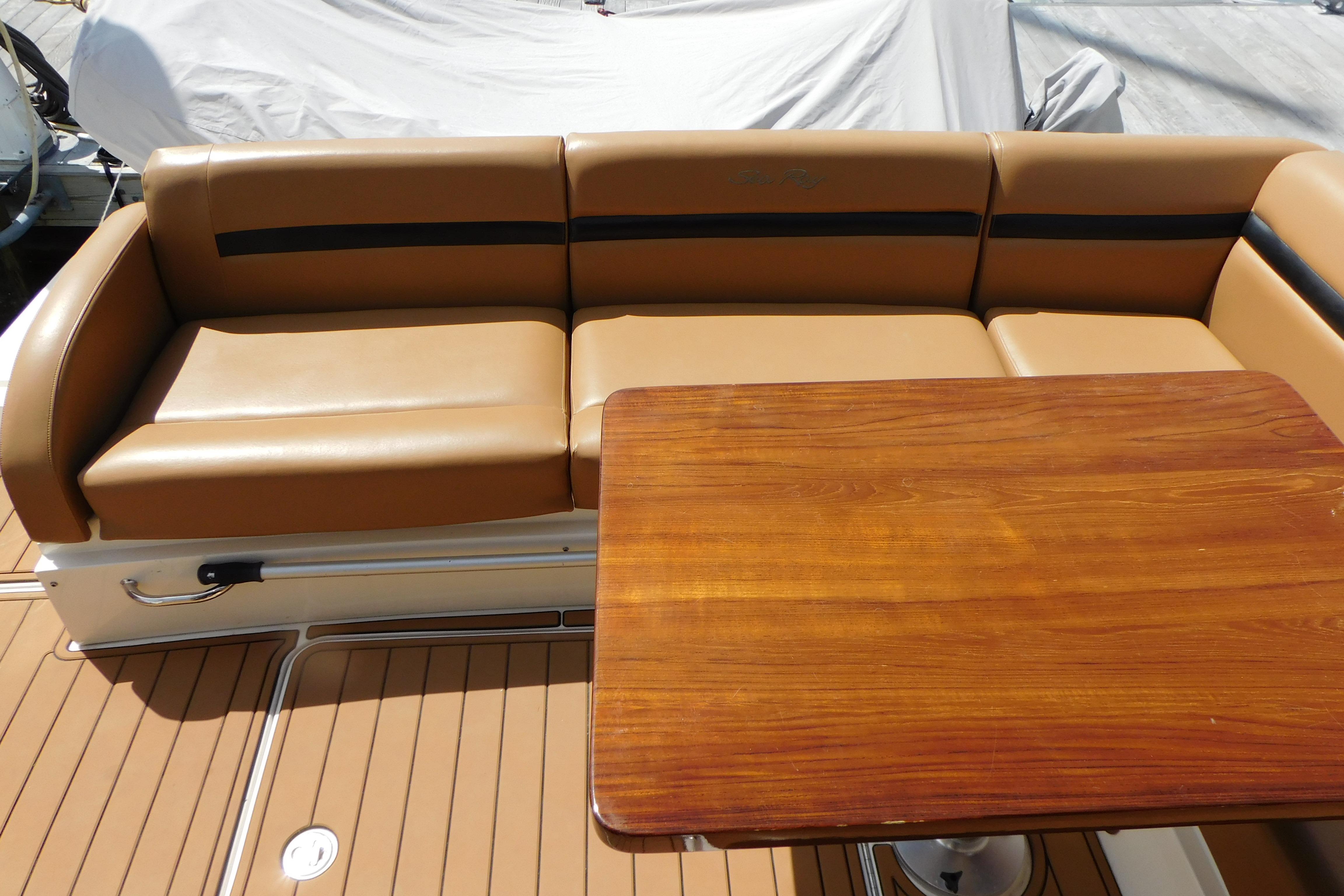 Luxurious seating and wooden table on 2013 Sea Ray 510 Sundancer yacht.