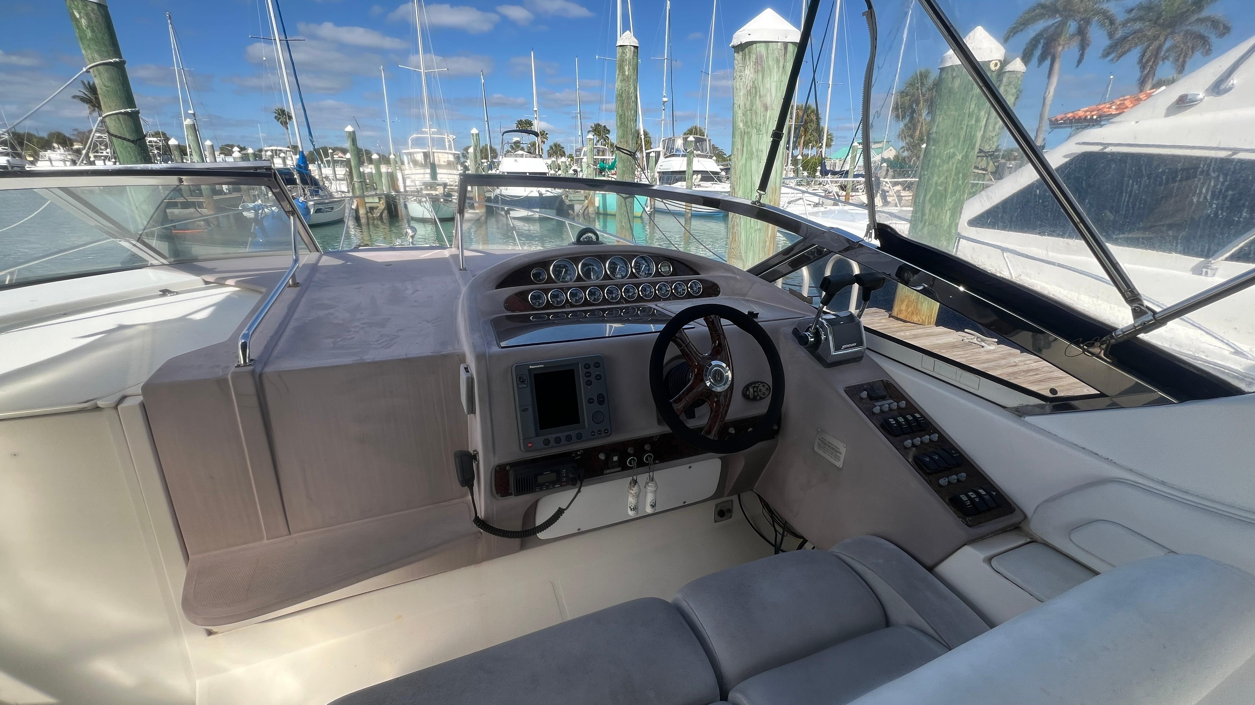 Cockpit of 2003 Regal Commodore 3260 yacht with steering wheel and navigation controls.