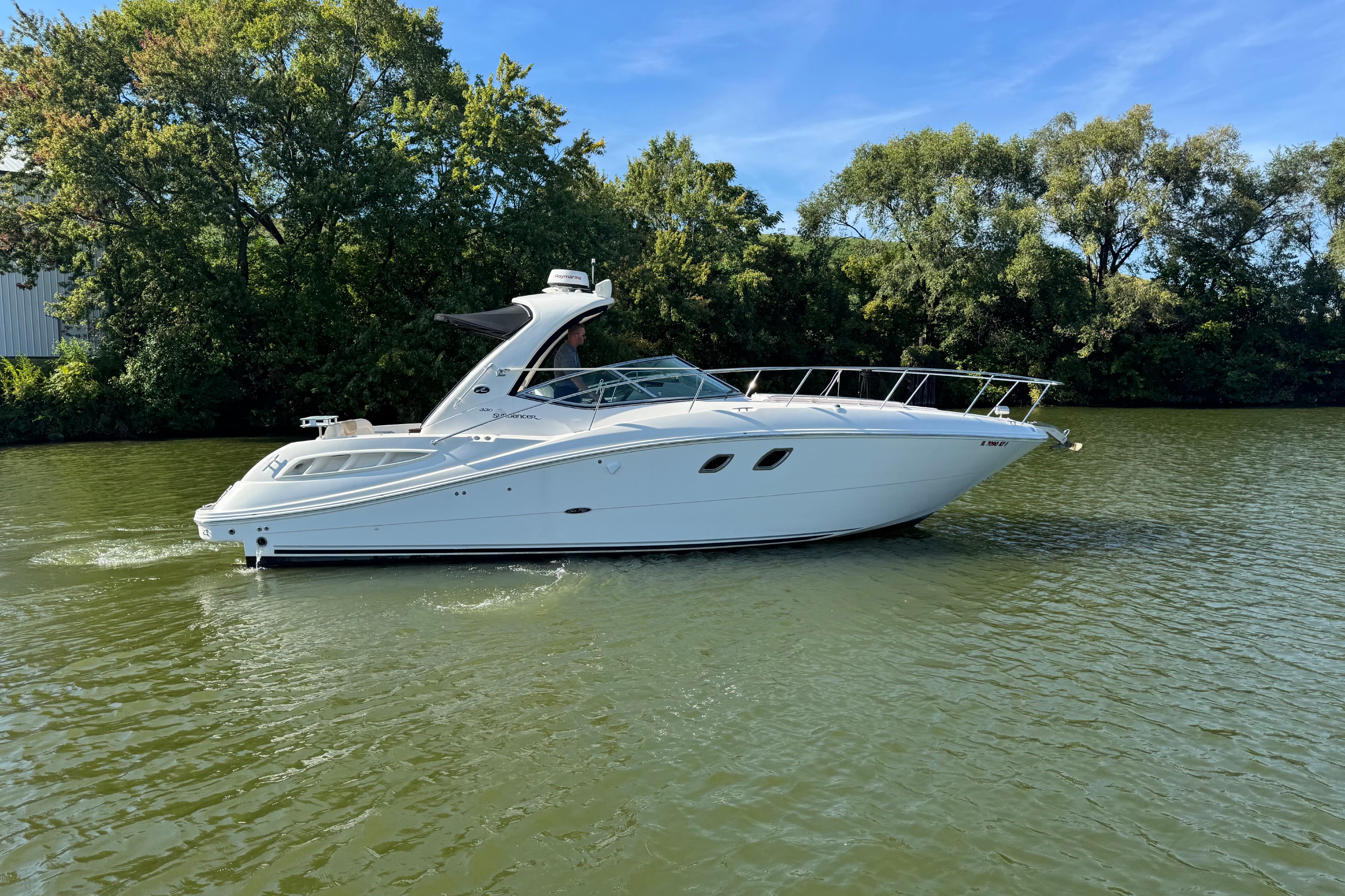 2008 Sea Ray 350 Sundancer cruising on a calm river with lush green trees.