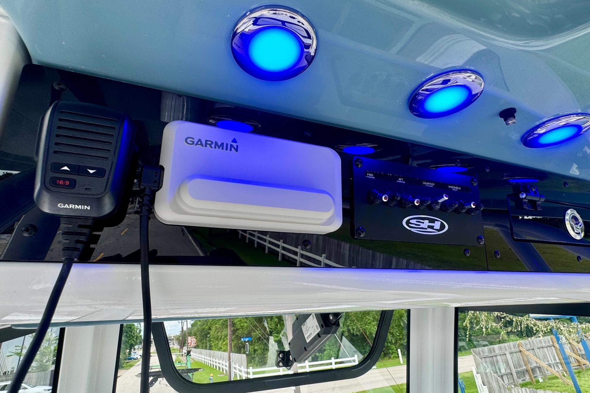 Interior electronics of 2026 Sea Hunt Ultra 275 SE boat with Garmin devices and blue LED lights.