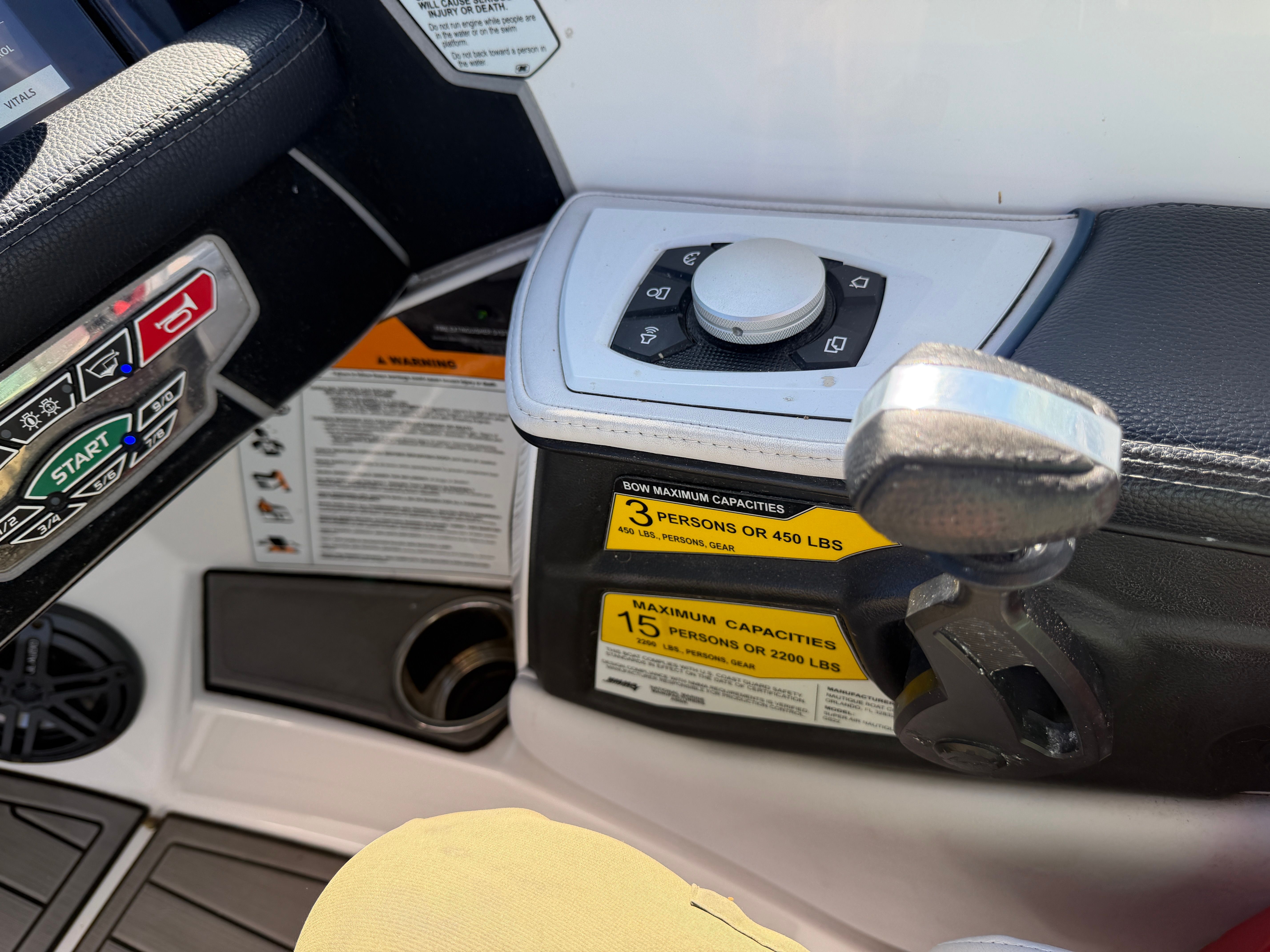 Close-up of the control area in a 2018 Nautique Super Air Nautique GS22 with controls and warning labels.