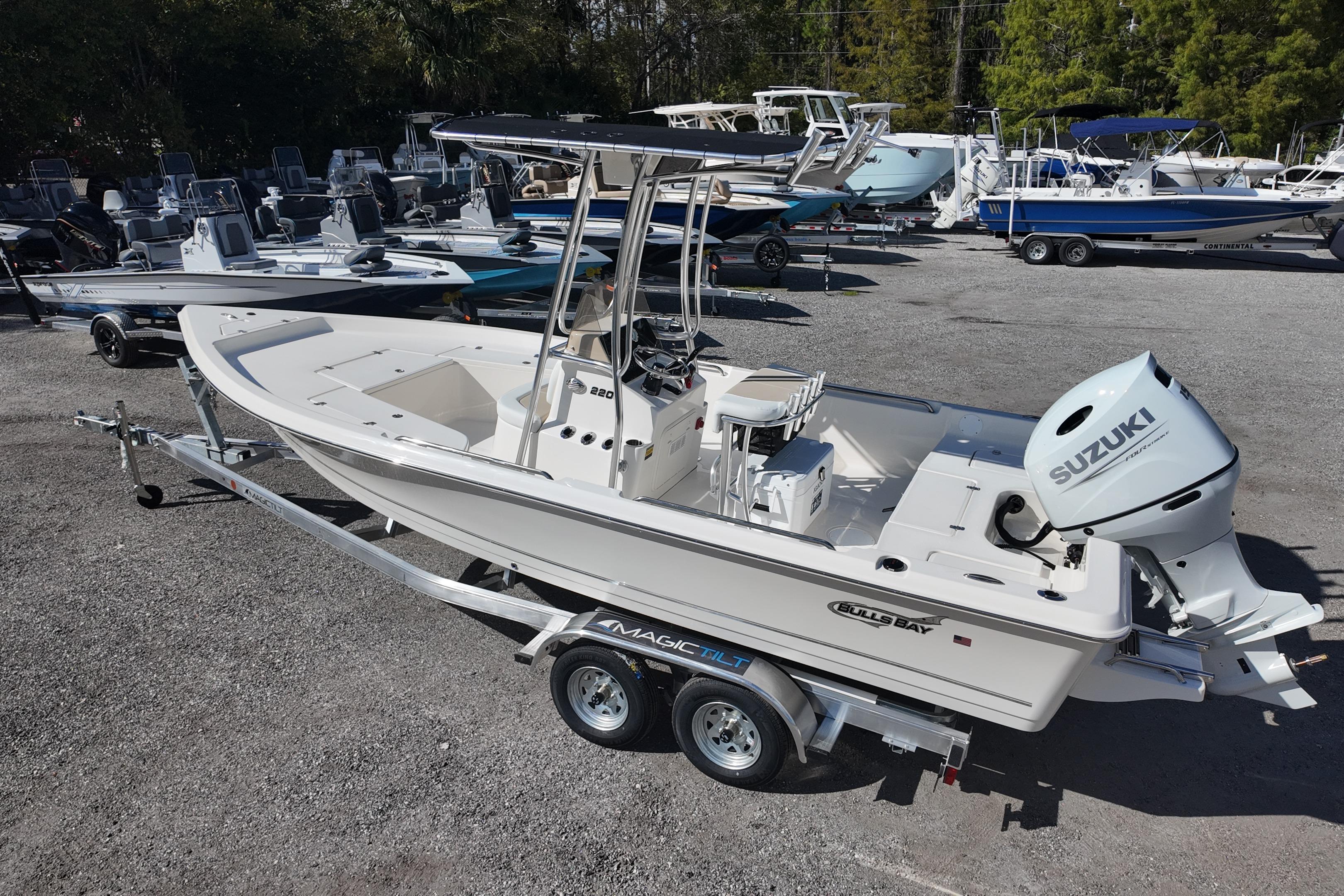 2026 Bulls Bay 2200 boat with Suzuki engine on trailer in a marina.
