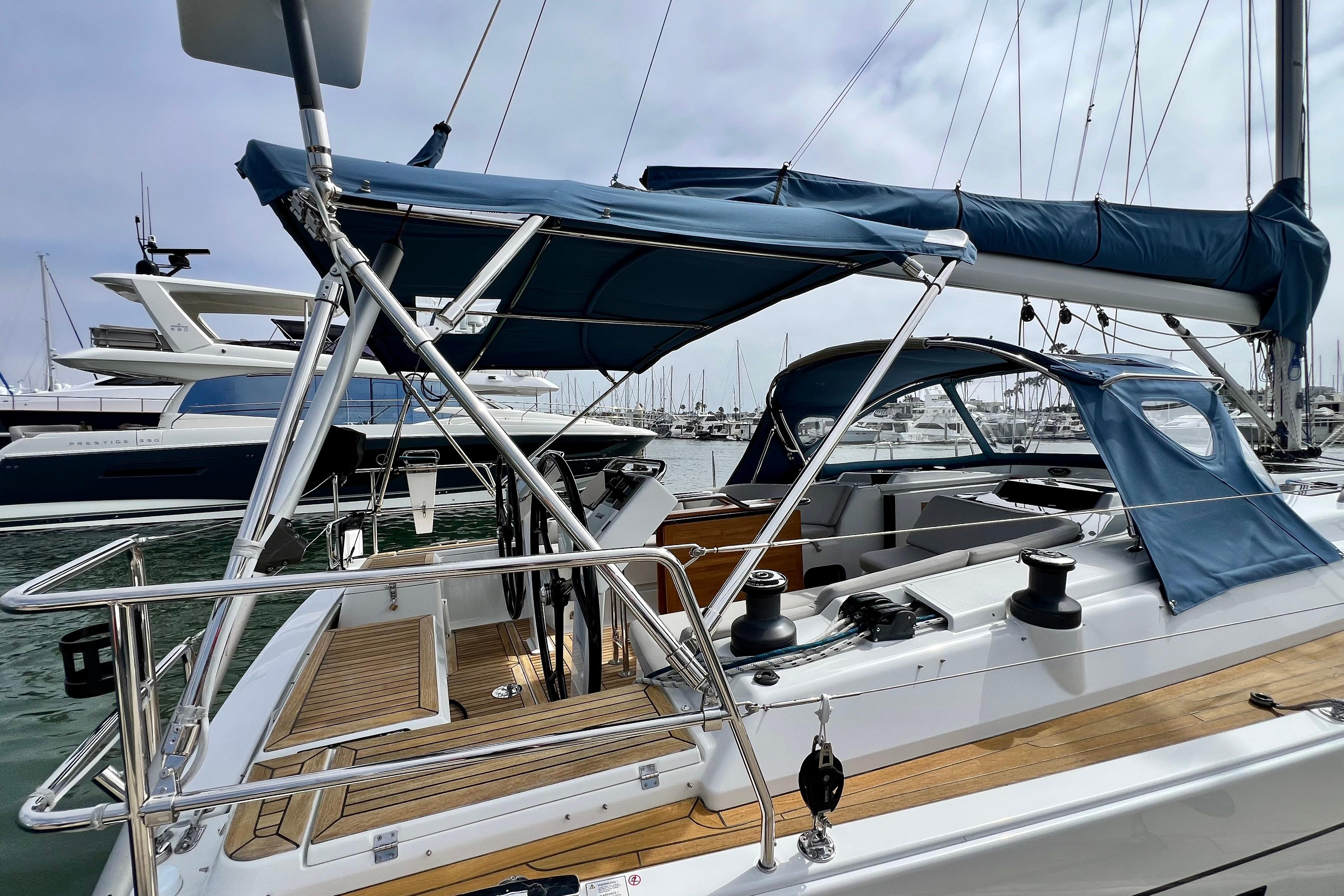 2016 Hanse 455 sailboat with blue canopy, docked in a marina.