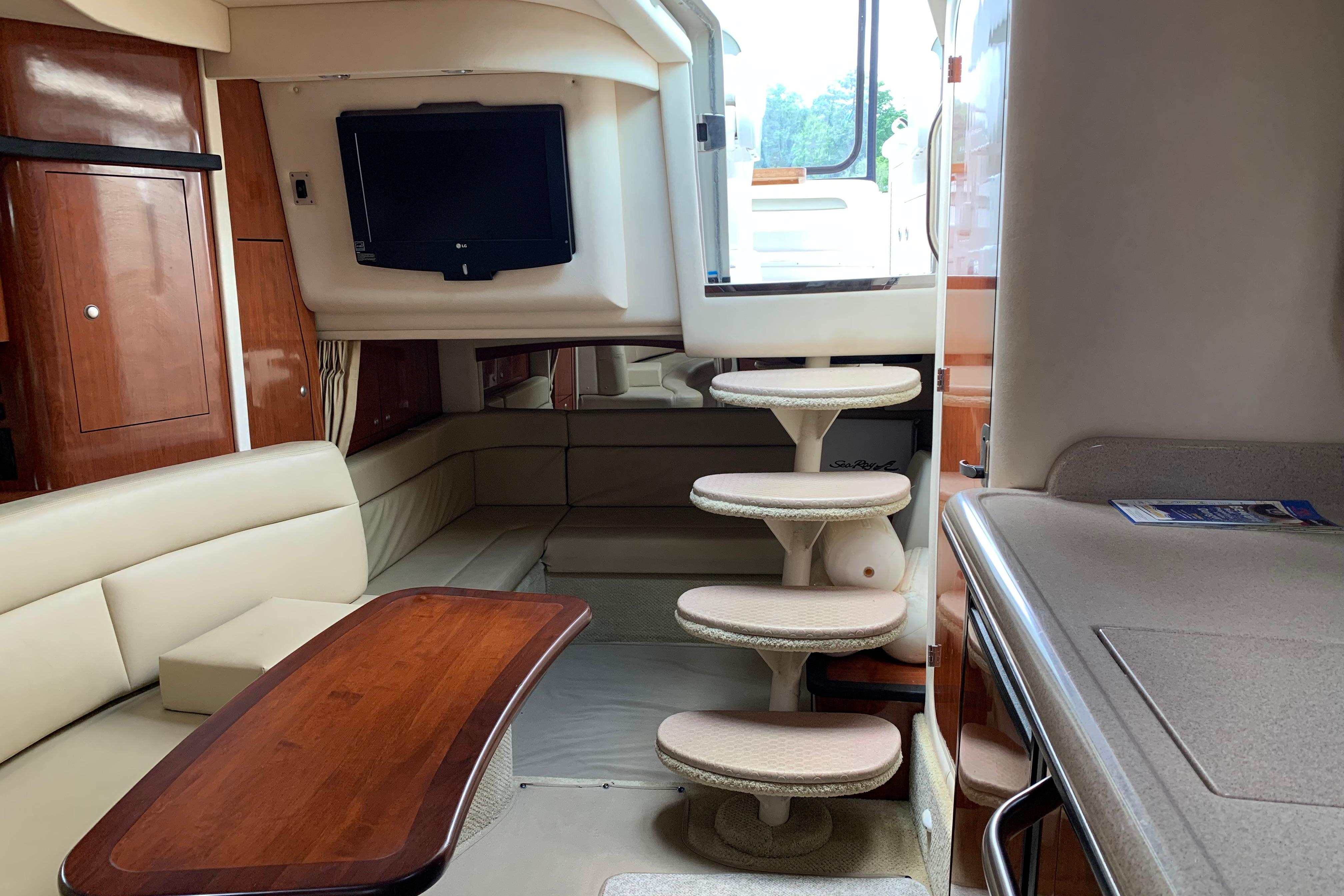 Interior of 2007 Sea Ray 340 Sundancer yacht with seating, table, and stairs.