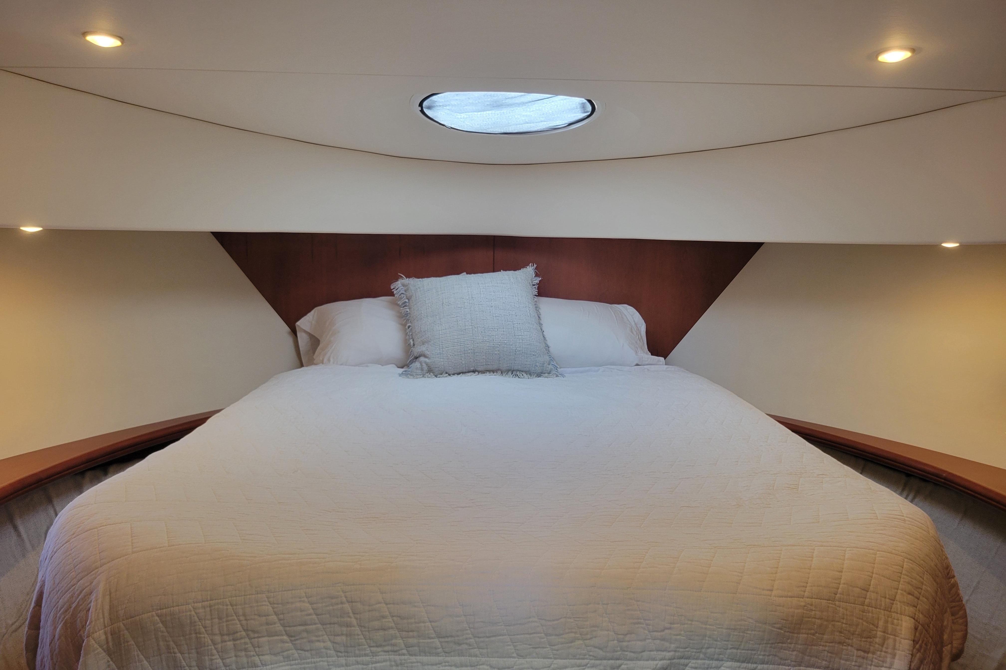 Luxurious bedroom interior of 2005 Silverton 43 Motor Yacht with cozy bedding.