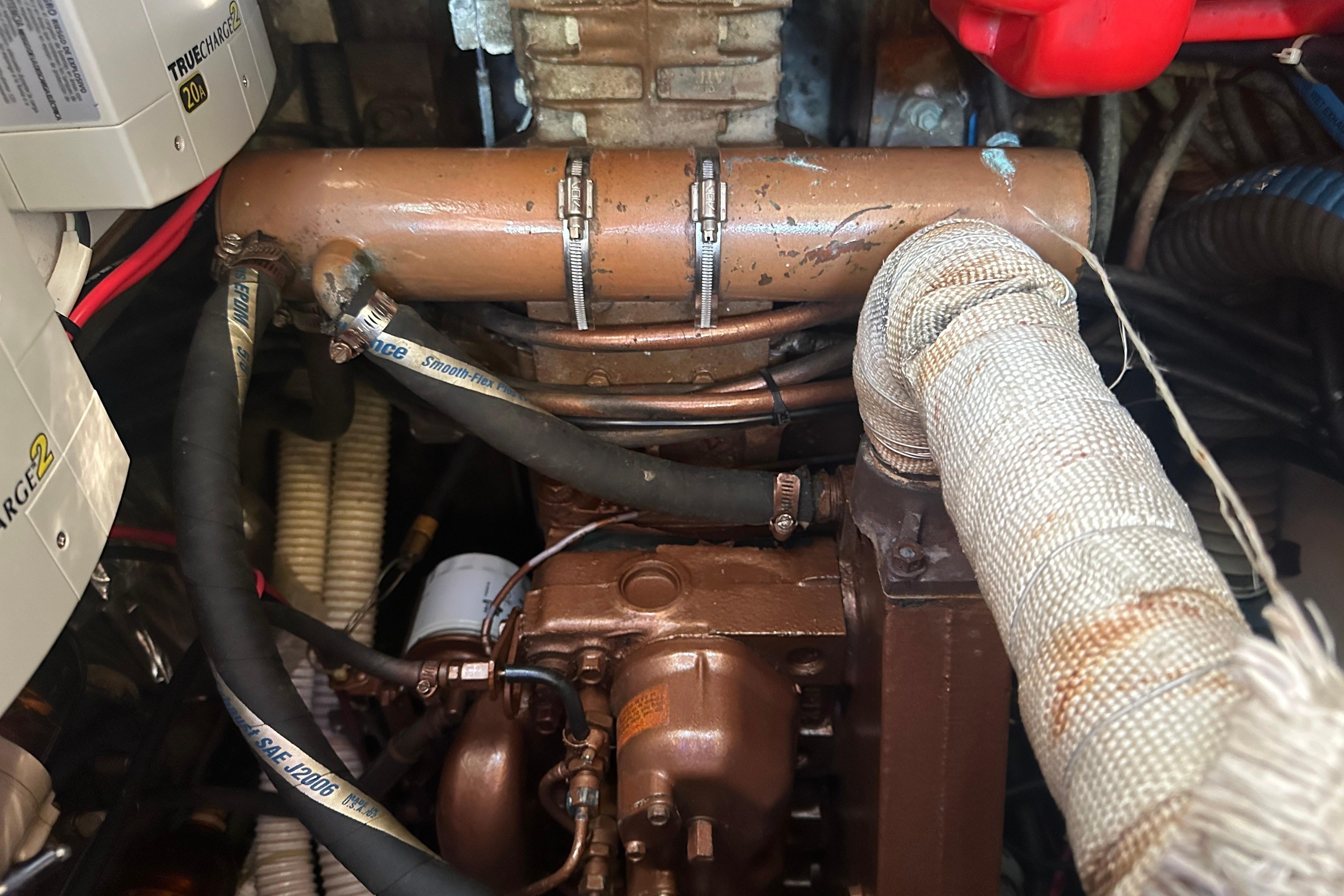 Engine compartment of a 1989 Nonsuch 36 sailboat, showing hoses and components.