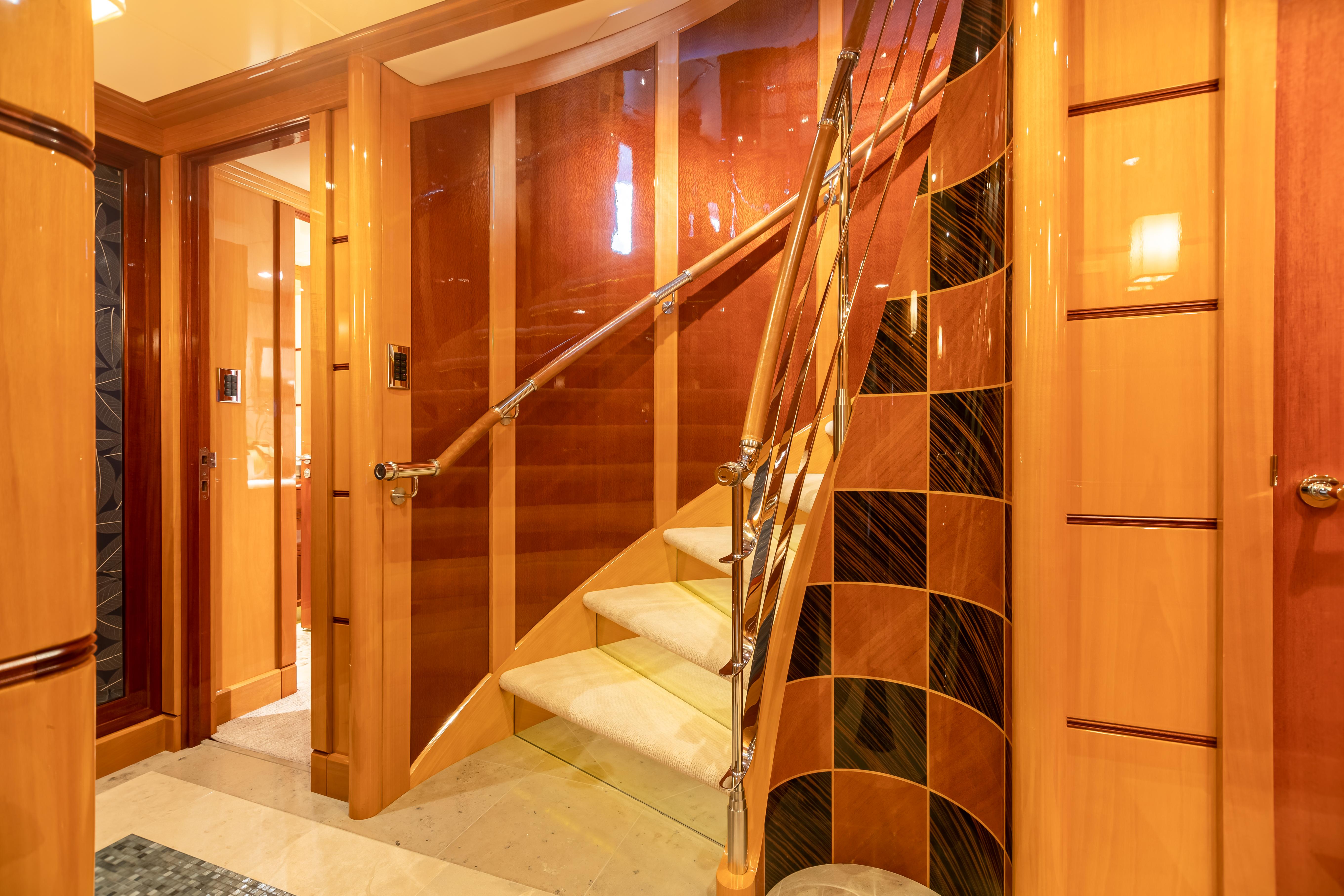 Luxurious interior staircase of 2011 Trinity Yachts CUSTOM model with elegant wood and metal finishes.