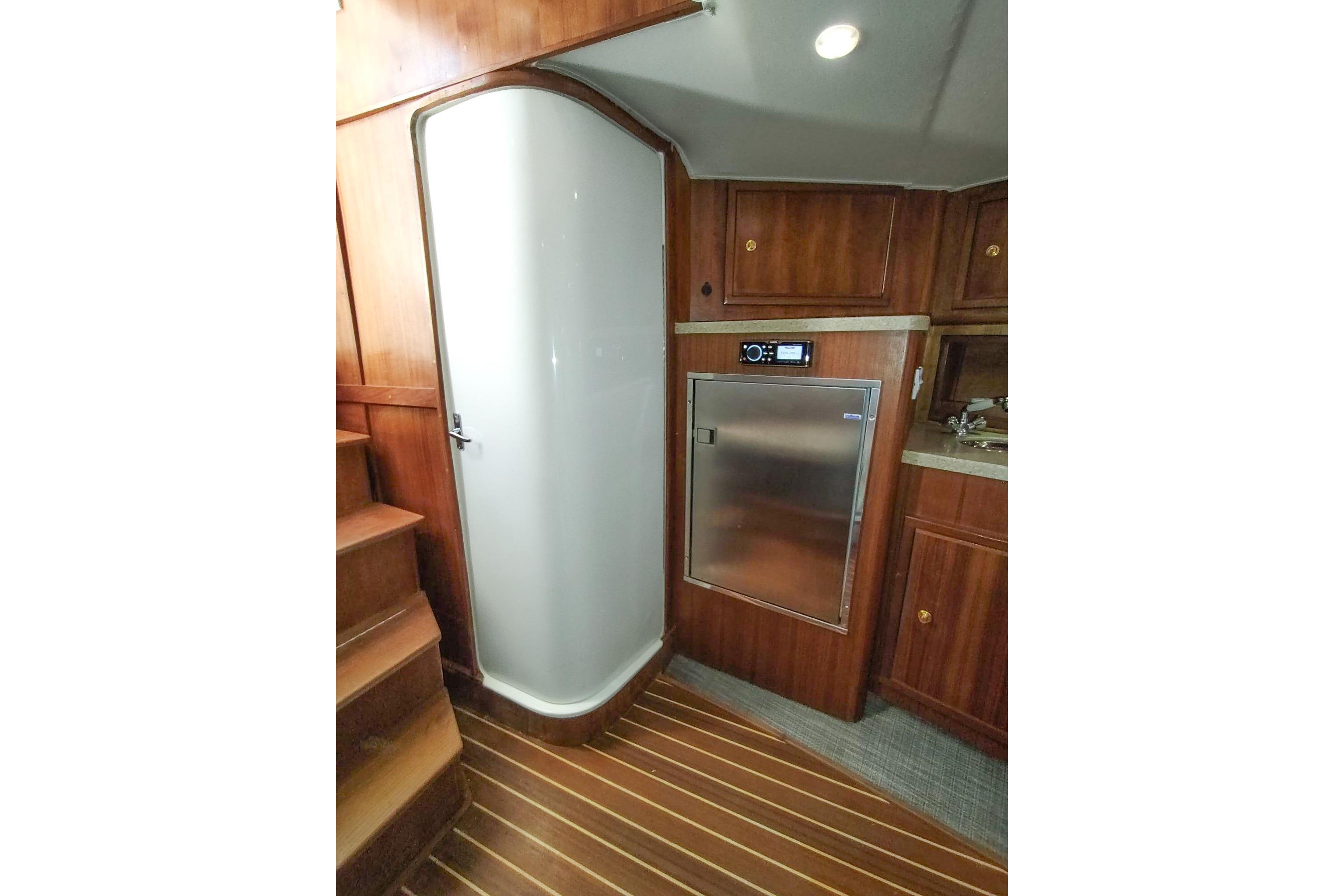 2017 Out Island SeaTek 36 Express interior with wooden cabinetry and compact shower.