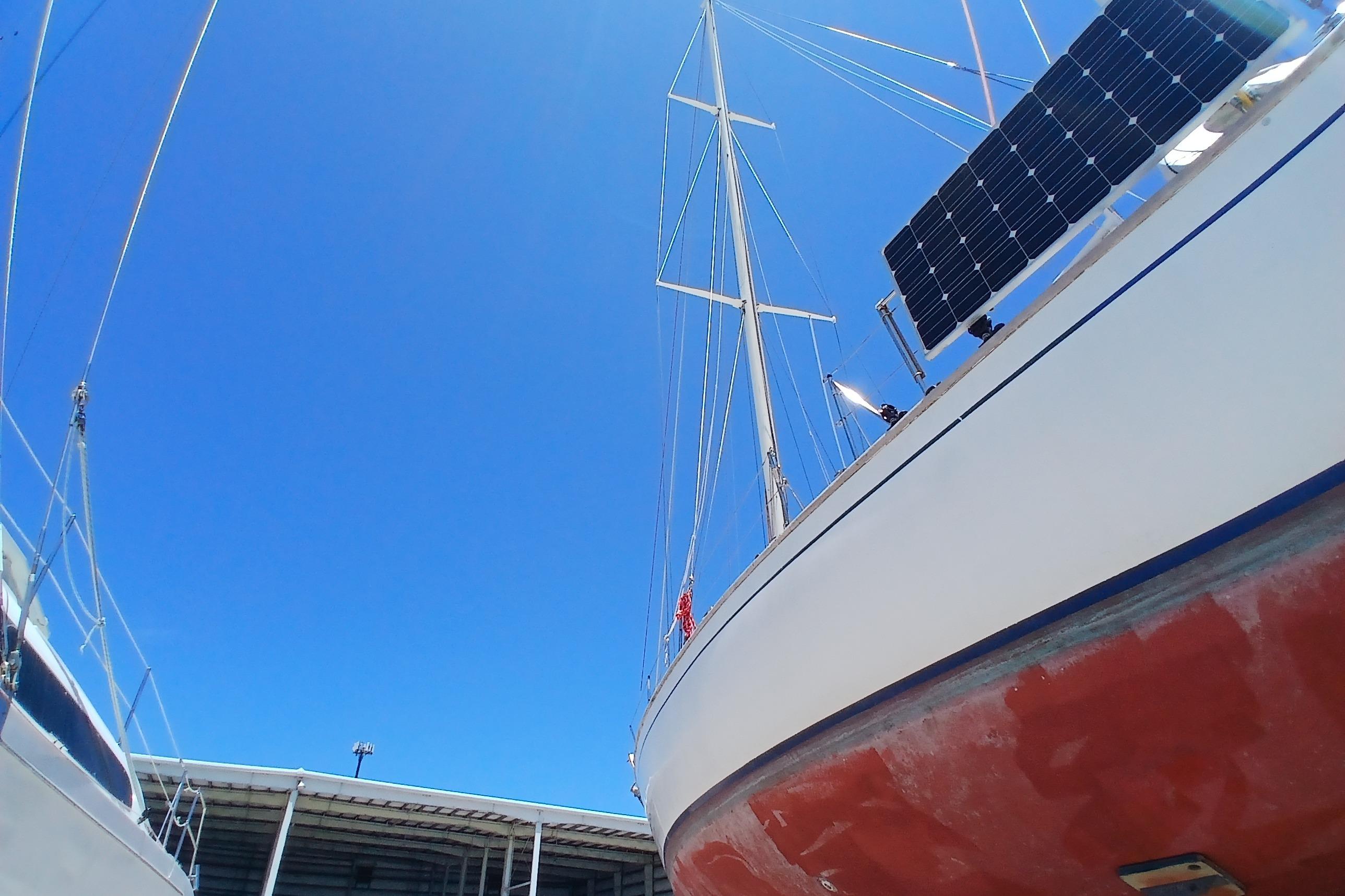 1981 Kaufman Skye 51 sailboat with solar panels under clear blue sky.