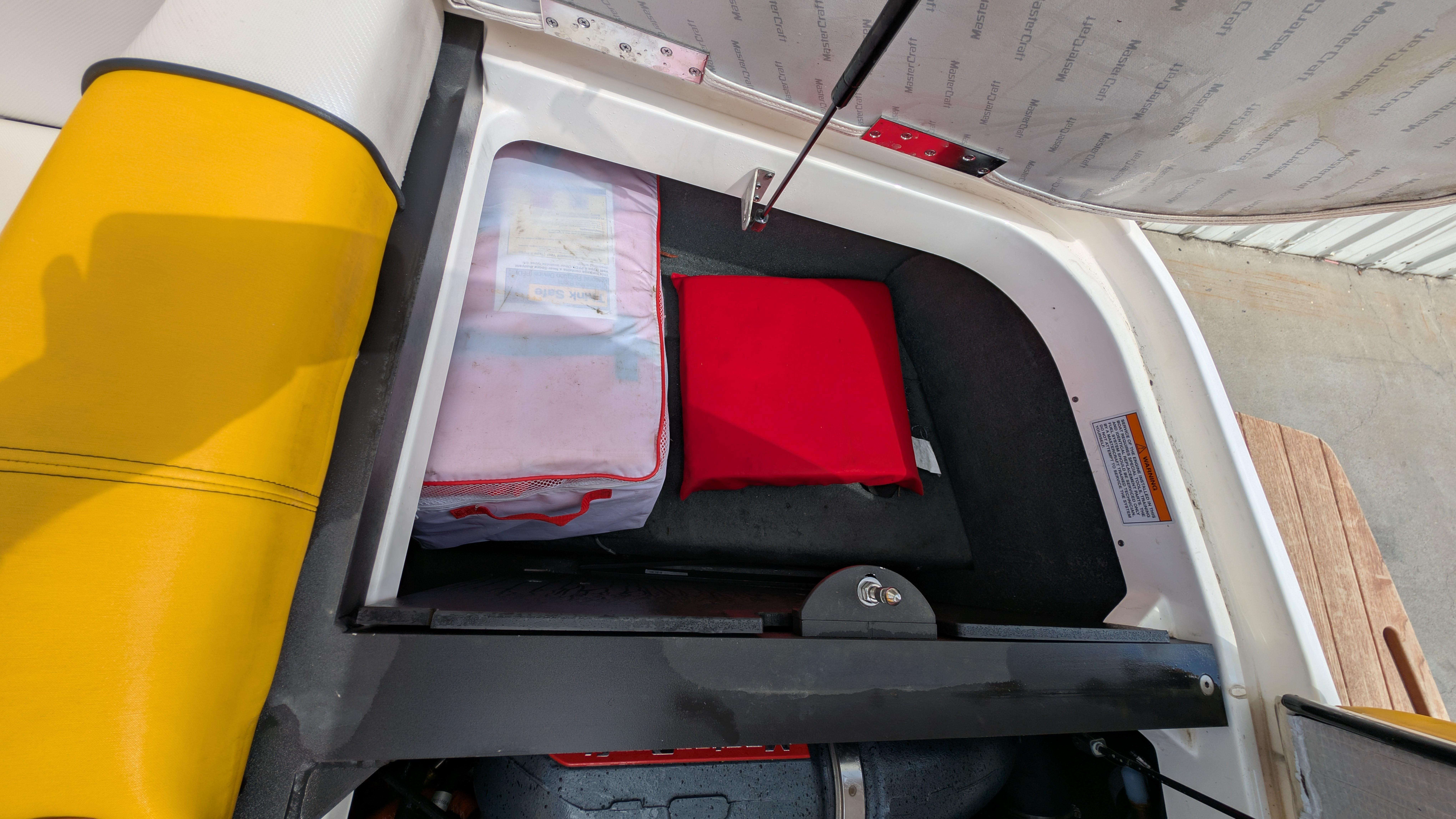 Storage compartment in a 2013 MasterCraft X2 boat with safety equipment.