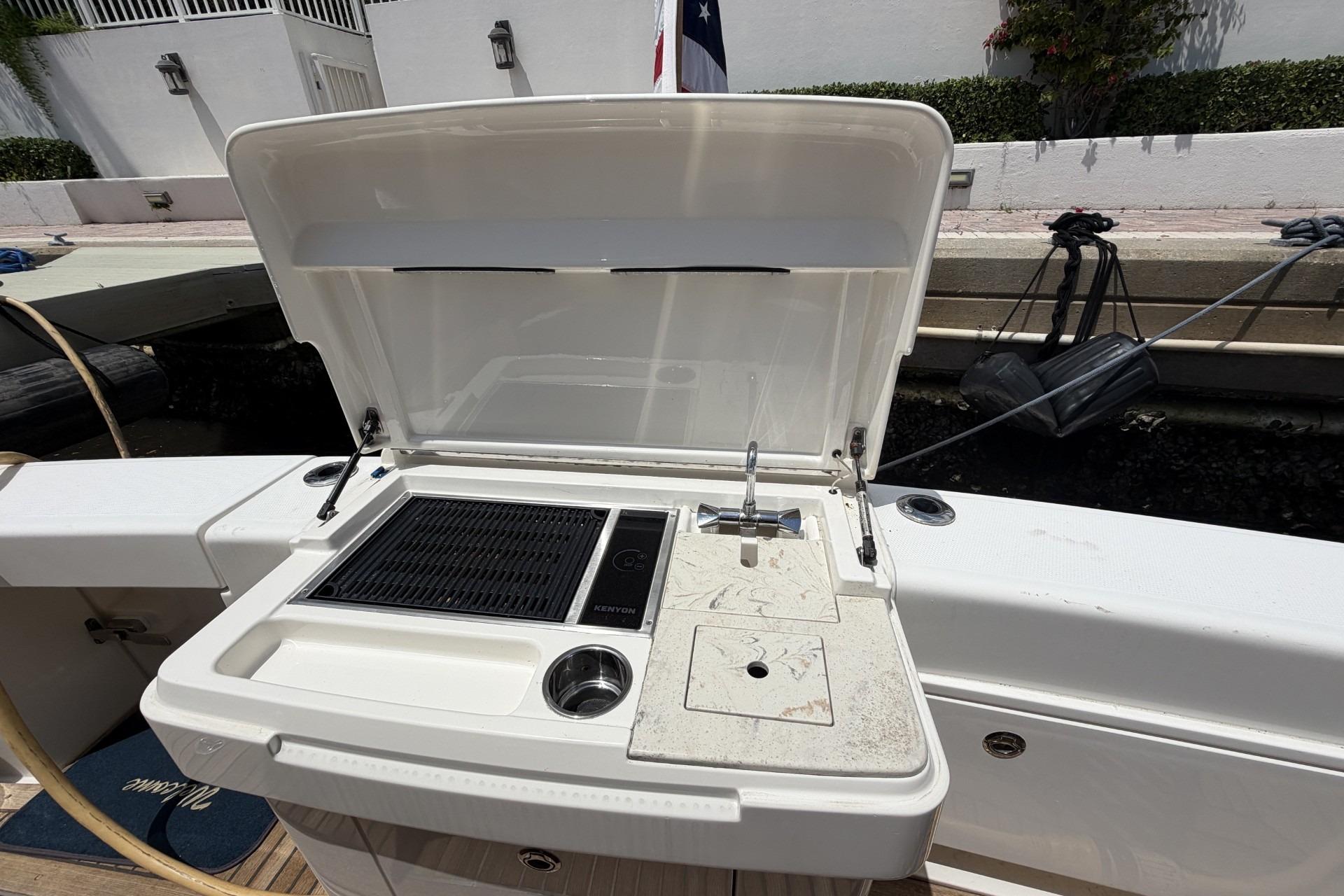Cockpit grill with sink and trash beside and storage below