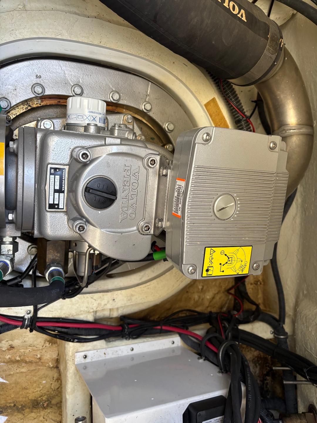 A Volvo Penta engine in a boat, surrounded by cables and hoses.