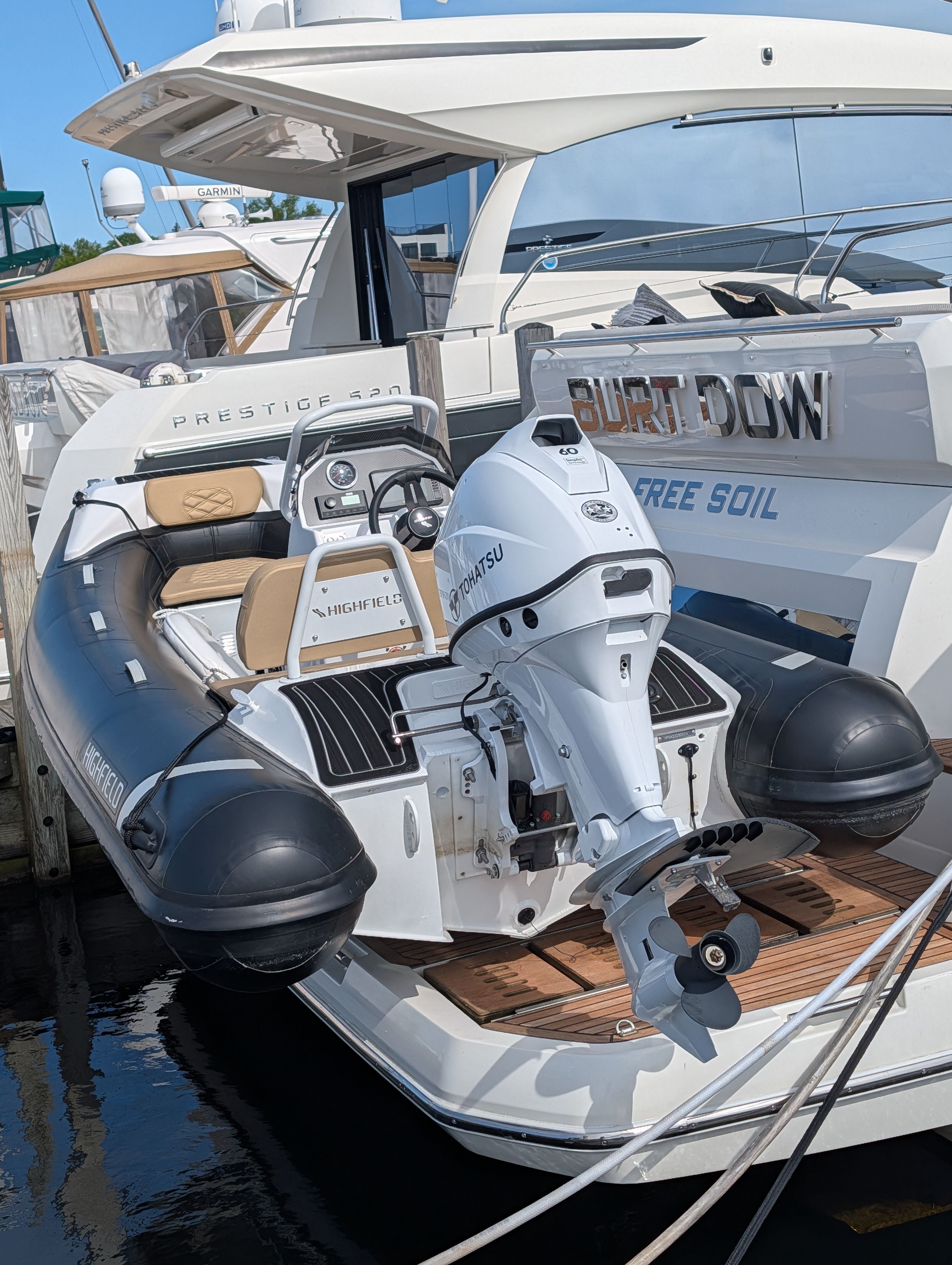2024 Highfield Sport 390 inflatable boat with outboard motor at dock.