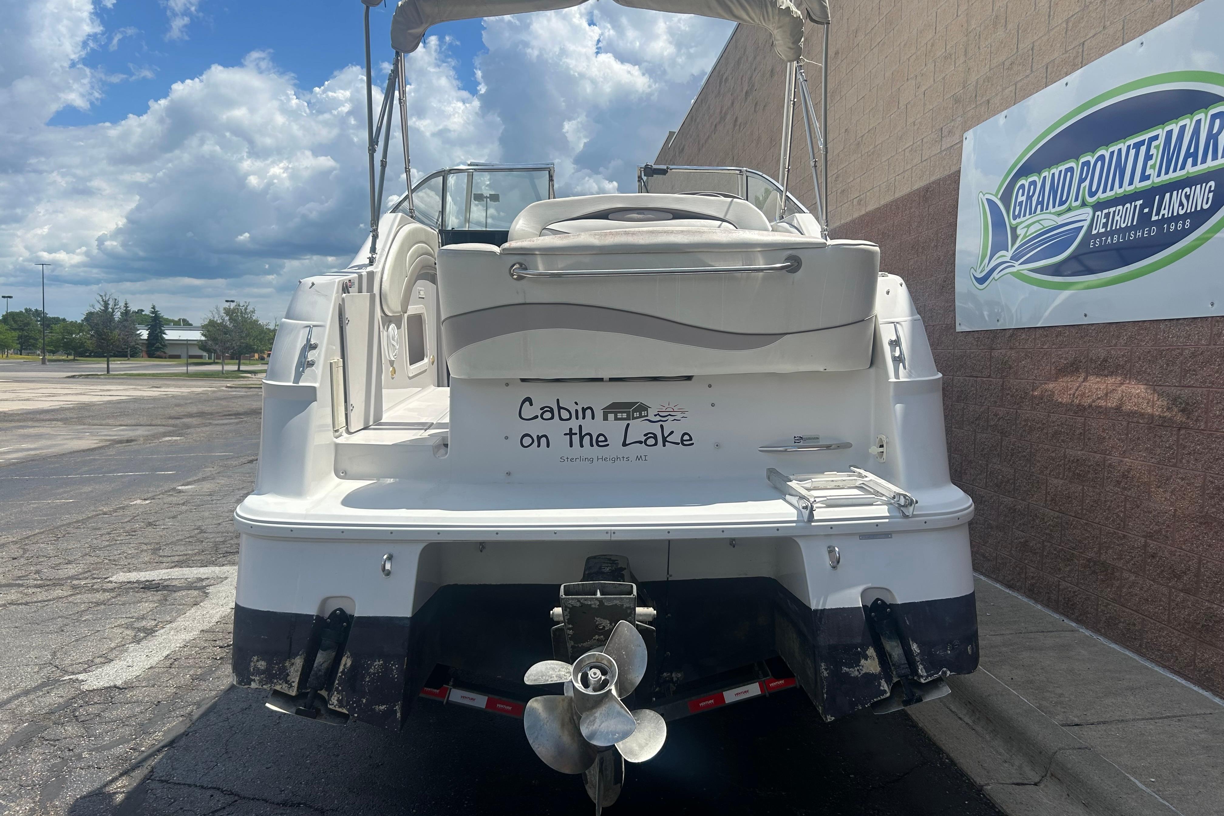1998 Four Winns 258 Vista boat parked near Grand Pointe Marina sign.